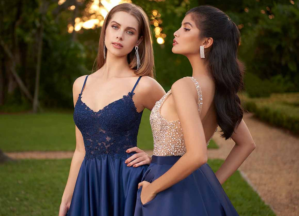 Two teens in prom dresses showing off their jewelry prom accessories.