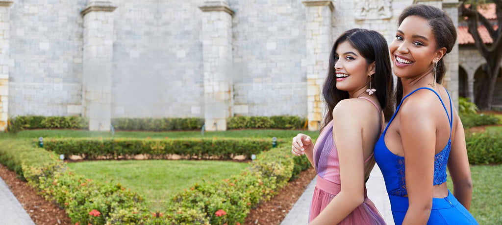 Side image of two girls smiling next to a garden background.