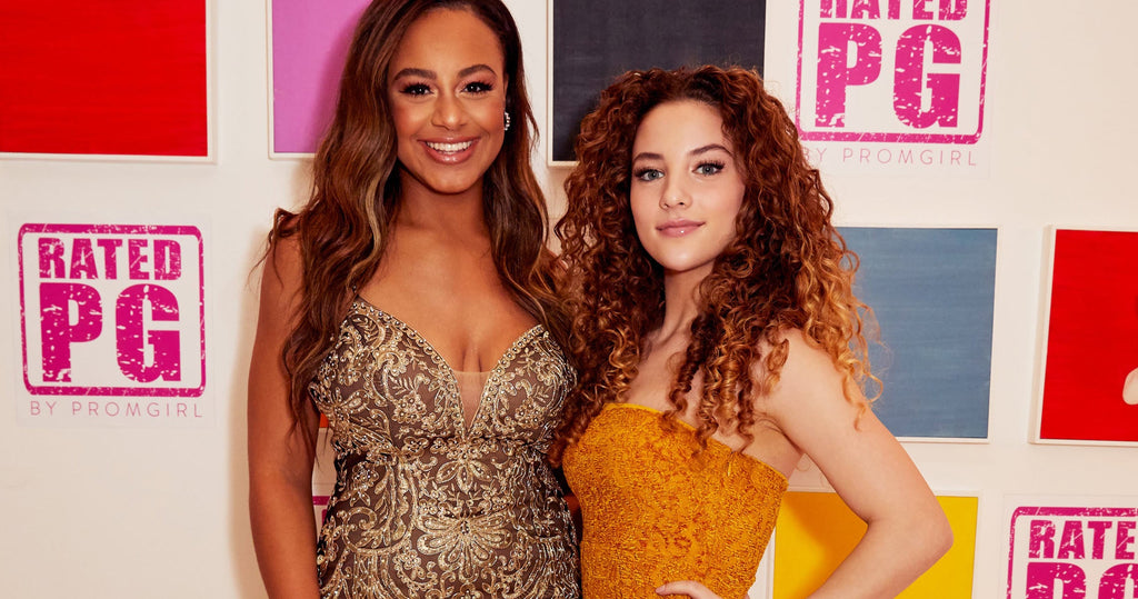 Two girls in unique prom dresses against a Rated PG by PromGirl backdrop.