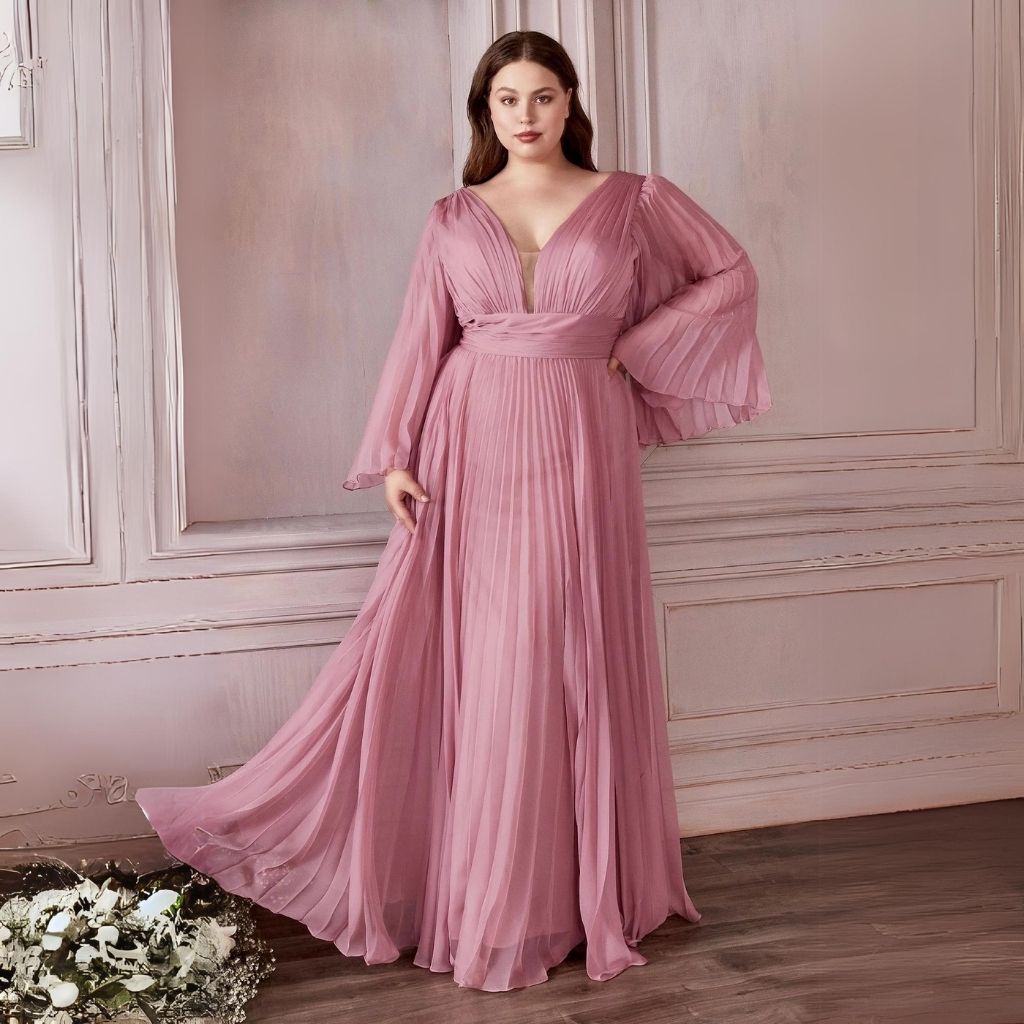 Wearing a plus-size pink pleated dress with long flutter sleeves, a woman gets ready for a formal event.