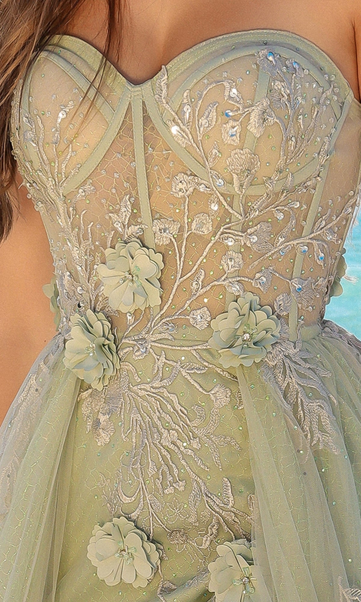 Close-up of the Strapless Sheer-Corset Long Tulle Prom Dress TM1002, featuring a sheer bodice, silver embroidery, floral appliqués, and light green tulle—an elegant choice for special occasions.
