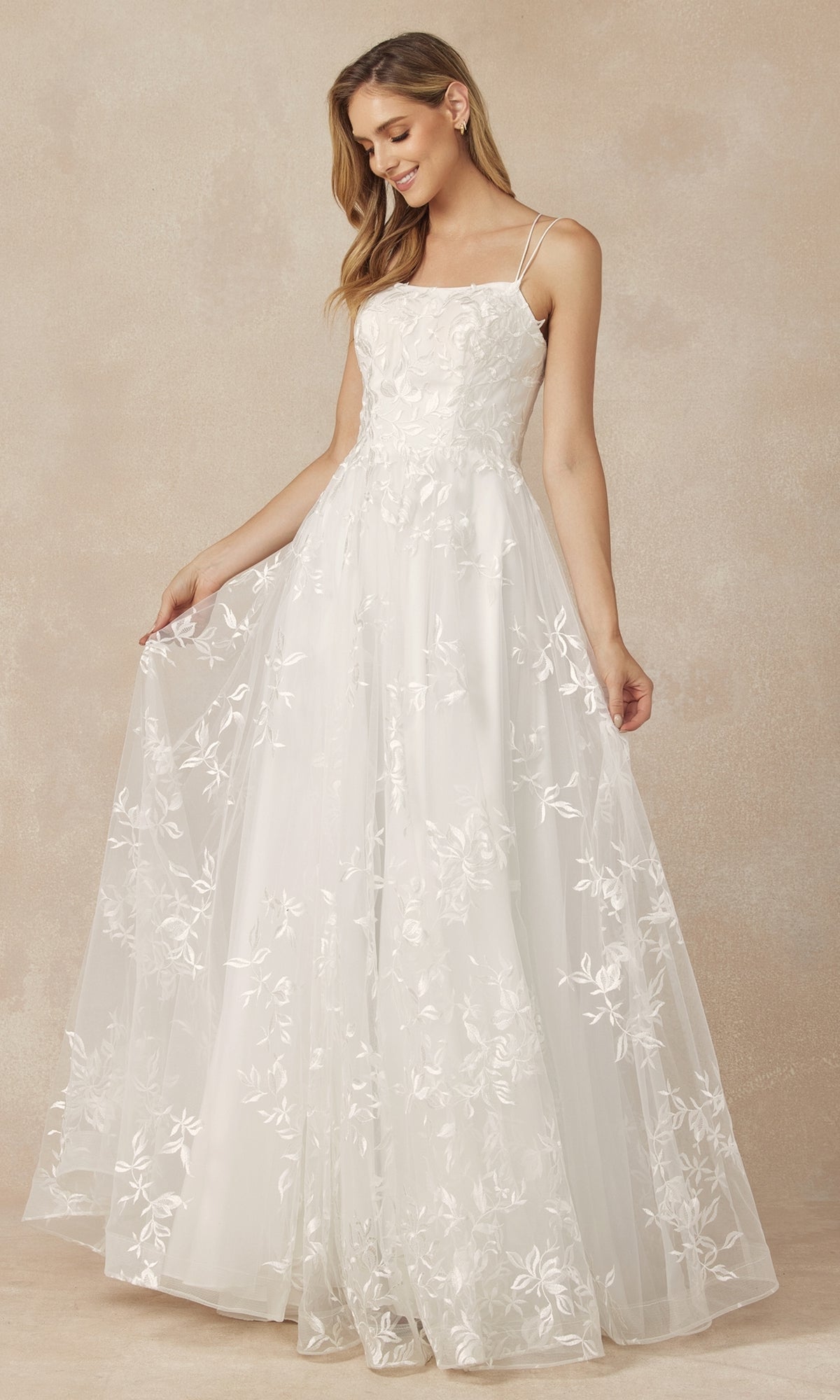 A woman models the Embroidered-Lace Long A-Line Prom Ball Gown 279 against a beige background, holding the skirt out to the side.
