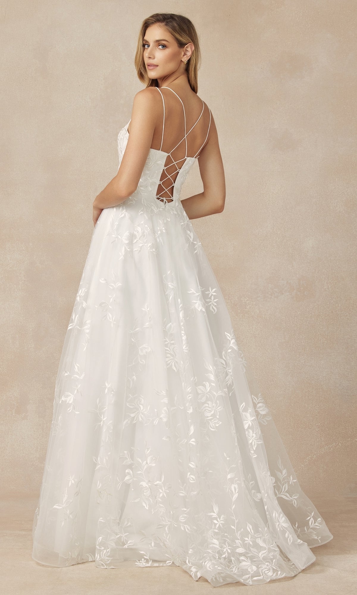 A woman wearing the Embroidered-Lace Long A-Line Prom Ball Gown 279, featuring a fitted bodice, crisscross back straps, and a flowing skirt, stands against a neutral background.