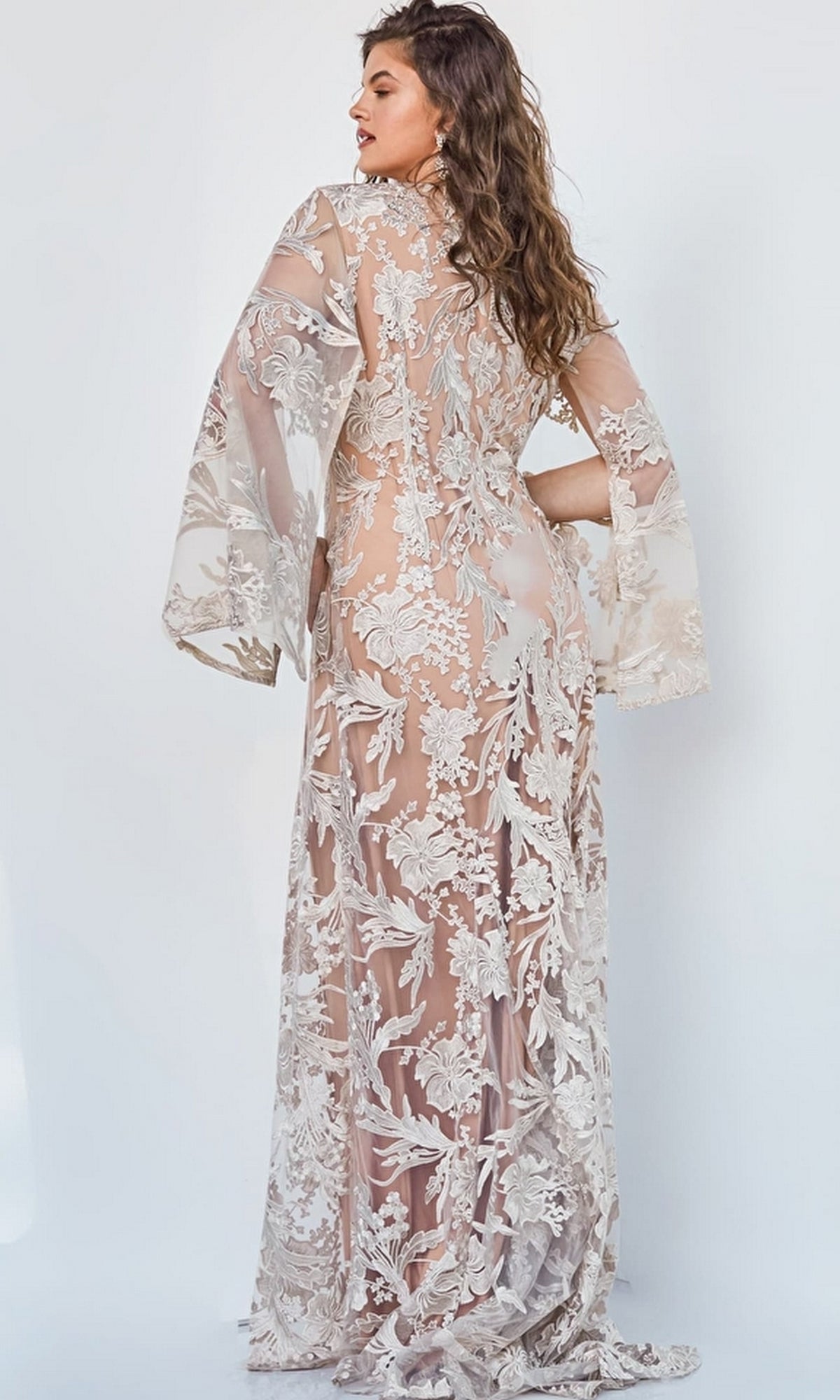 A woman faces away in the Embroidered Long Formal Gown 00752 with wide sleeves and detailed white floral embroidery, set against a plain light background.