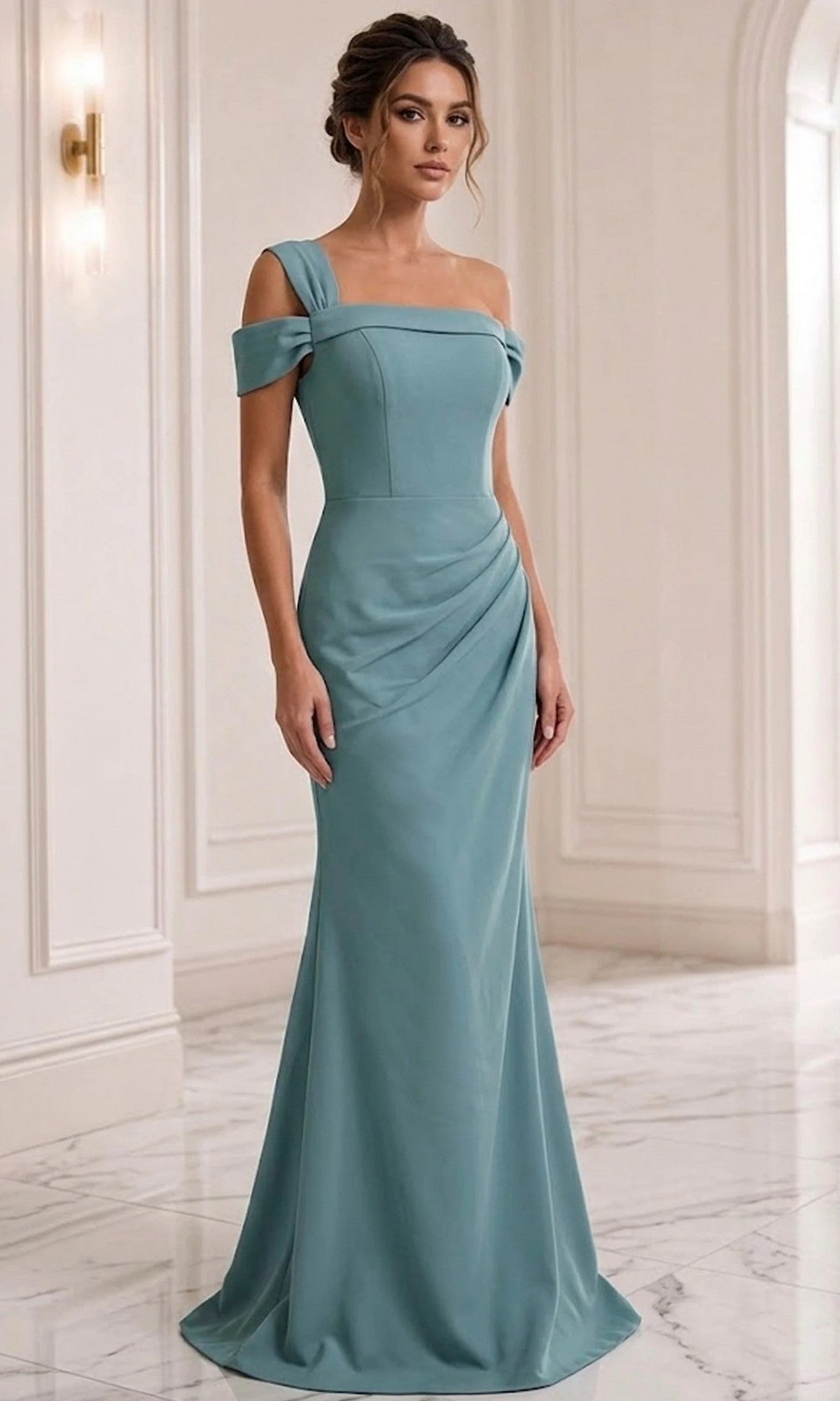 A woman wears the Long Formal Dress: Jovani 06723 in a fitted, seafoam off-the-shoulder design, featuring a graceful sheath silhouette as she stands in a marble-floored, white-walled interior with elegant wall molding—perfectly embodying the sophisticated charm of this Jovani formal gown.