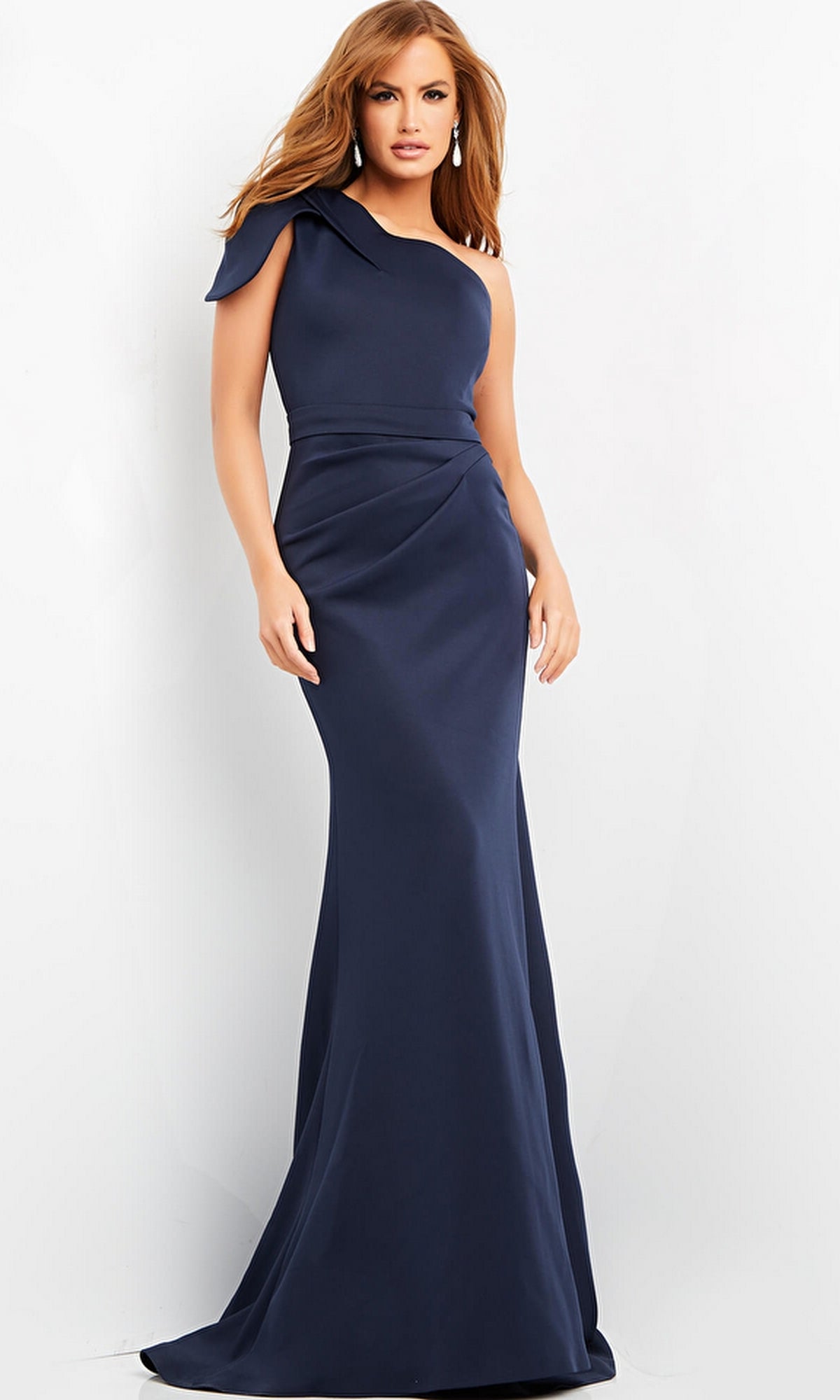 A woman poses against a white background in the Jovani 06753 Long Formal One-Shoulder Dress, showcasing a fitted bodice with subtle draping on the floor-length navy skirt.