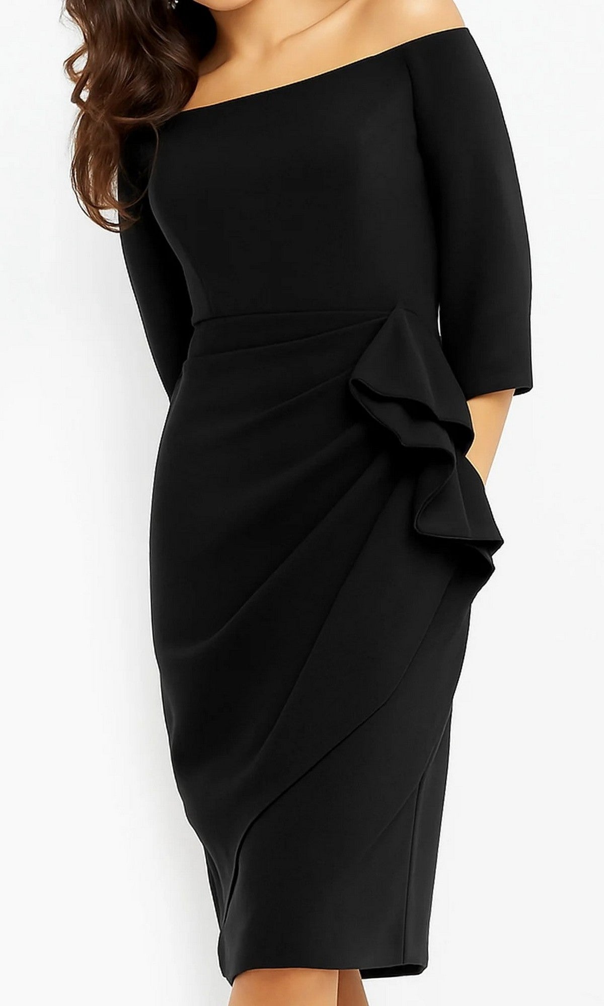 A woman poses elegantly against a white background, wearing the Jovani 07442 Short Wedding Guest Dress in black, designed with an off-shoulder neckline, knee-length hemline, three-quarter sleeves, and a striking side ruffle detail.