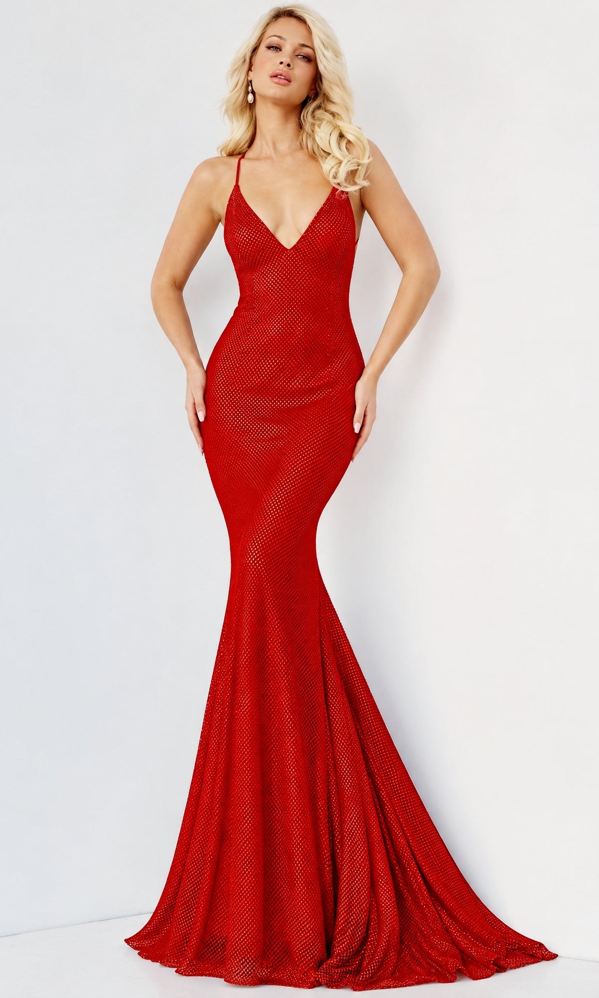 A woman wearing an Embellished Long V-Neck Prom Dress: Jovani 08139, a floor-length, red, v-neck mermaid gown with a subtle grid-like texture.