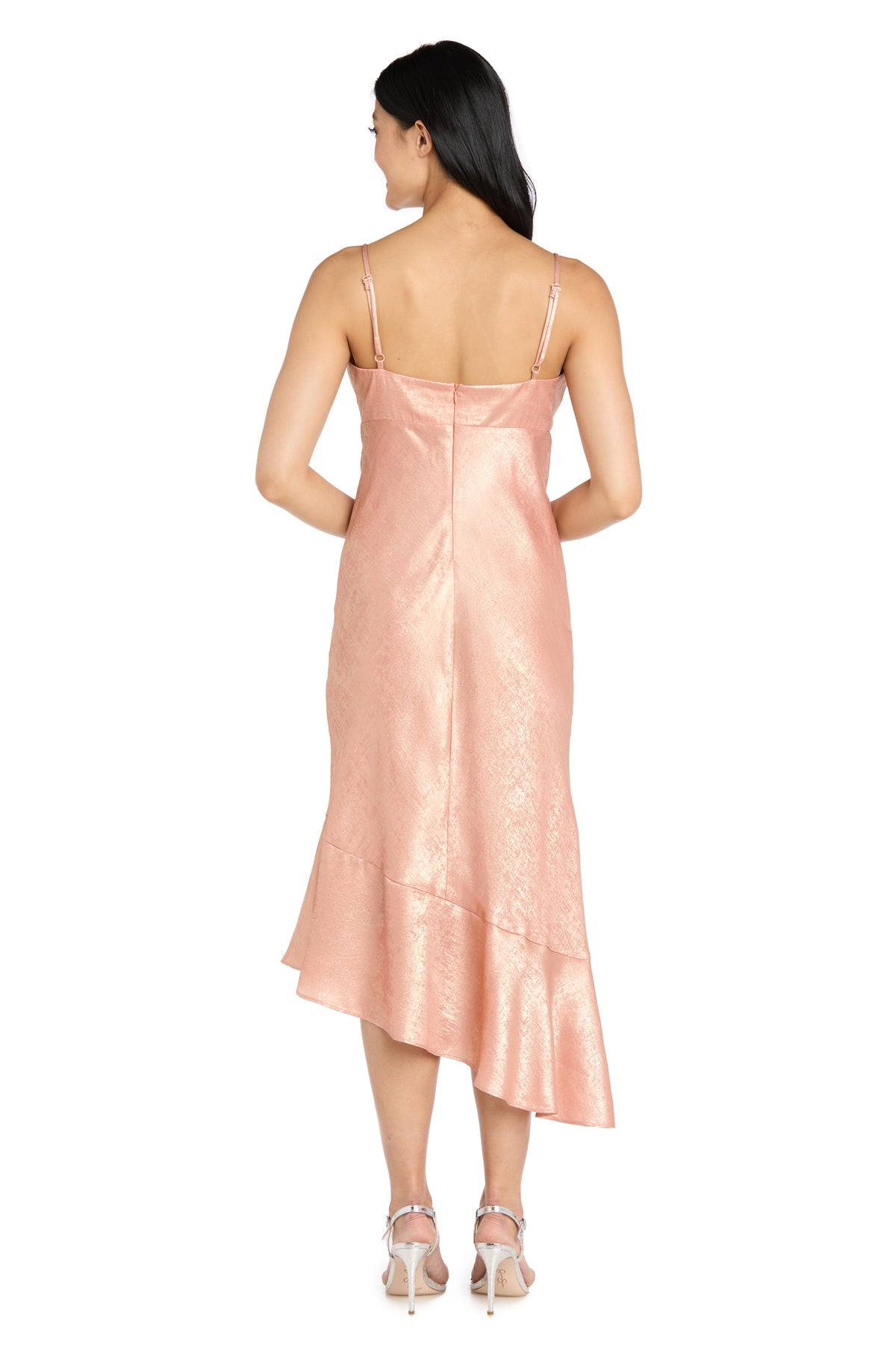 A woman faces away, wearing the Shimmer Midi Semi-Formal Dress: Morgan 10251 in light pink with thin straps and a ruffled hem, paired with high-heeled shoes.