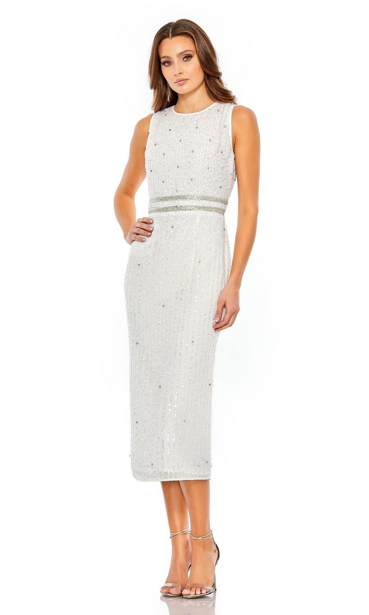 A woman in the Mac Duggal 10509 short sequin wedding guest dress with silver accents and high-heeled sandals stands against a plain white background.