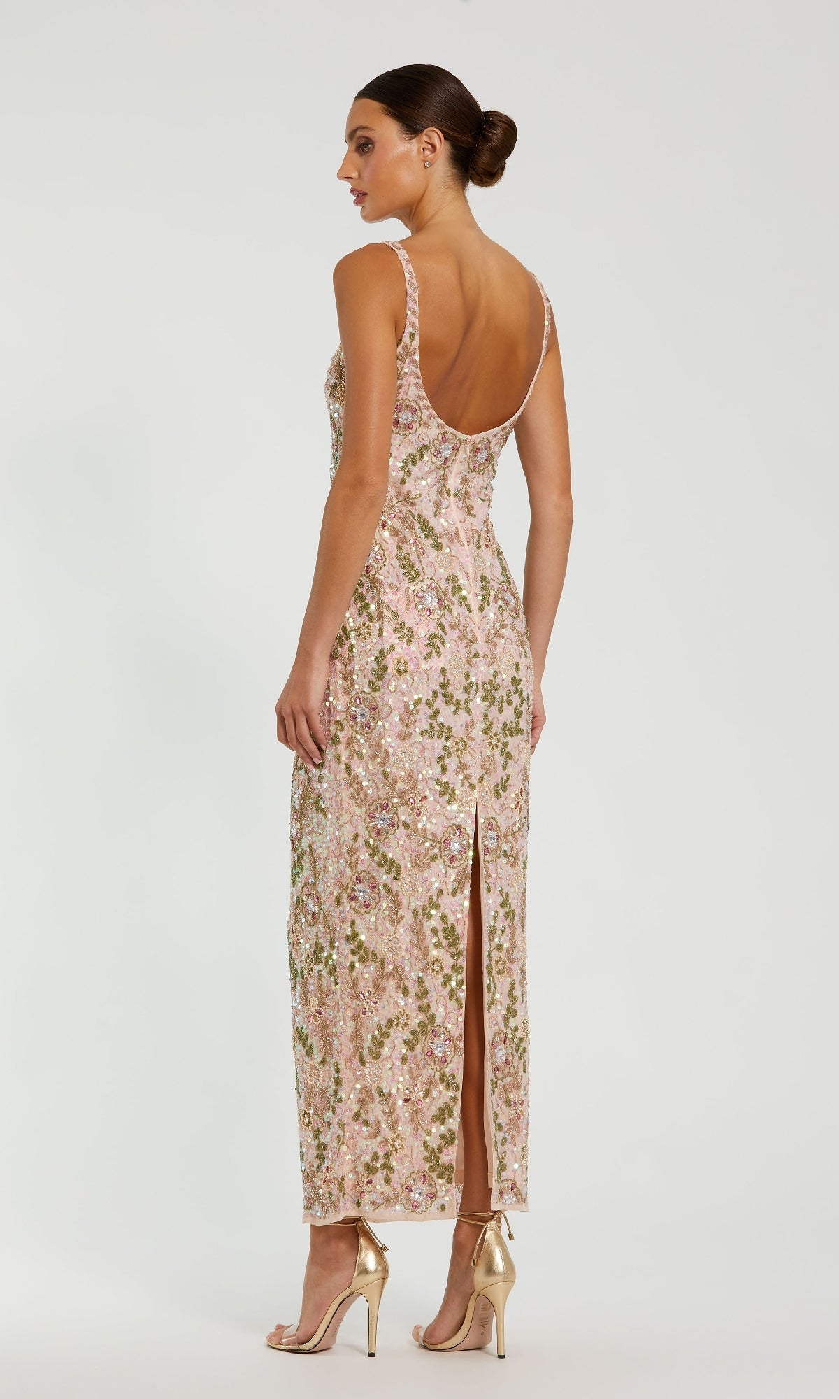 Woman in profile wears the Mac Duggal 10755 sequin formal dress with back slit, featuring a low back and floor-length design, paired with metallic high heels.