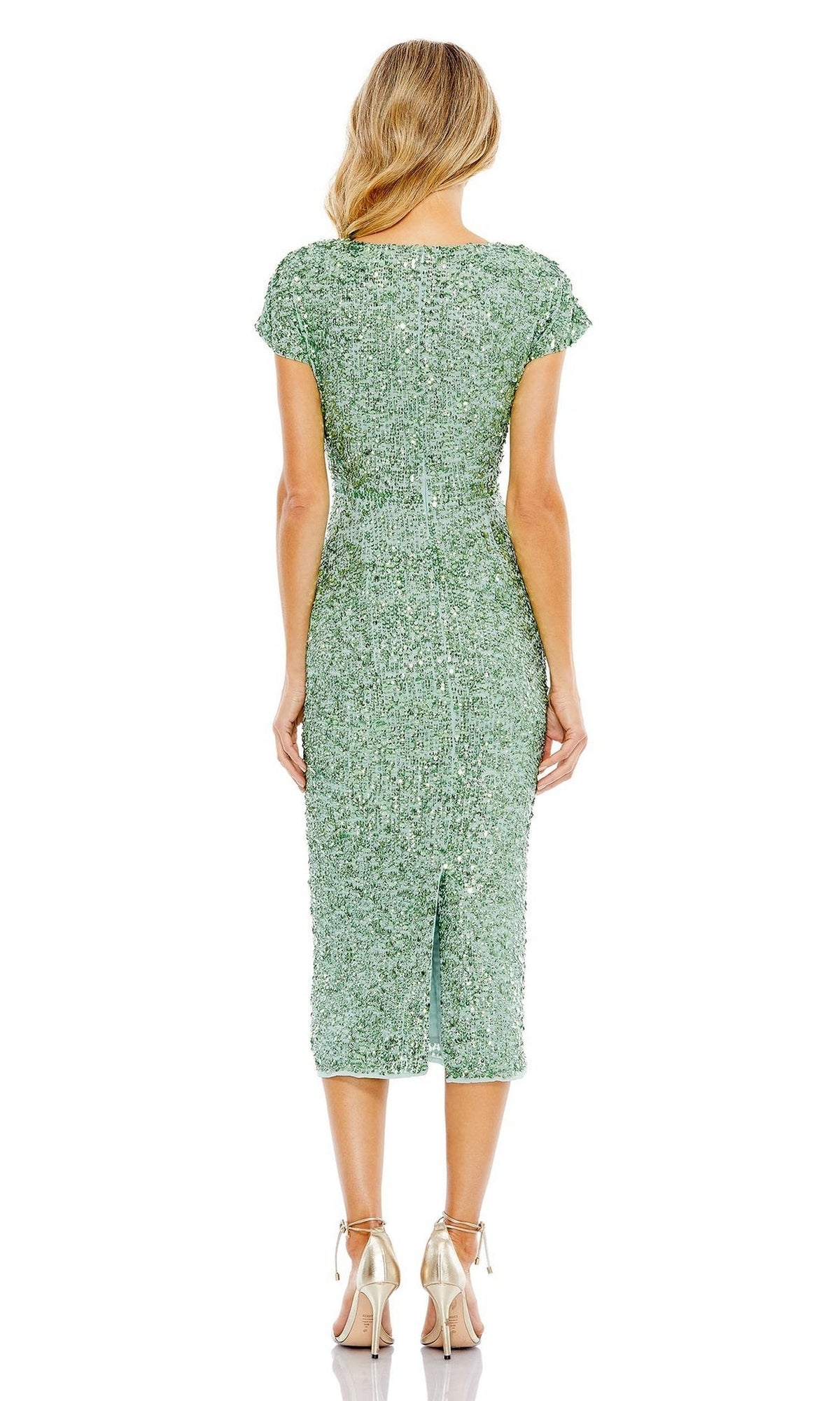 Woman faces away, wearing the fitted green Mac Duggal 10766 Midi Sequin Wedding Guest Dress with short sleeves and metallic high heels against a white background.
