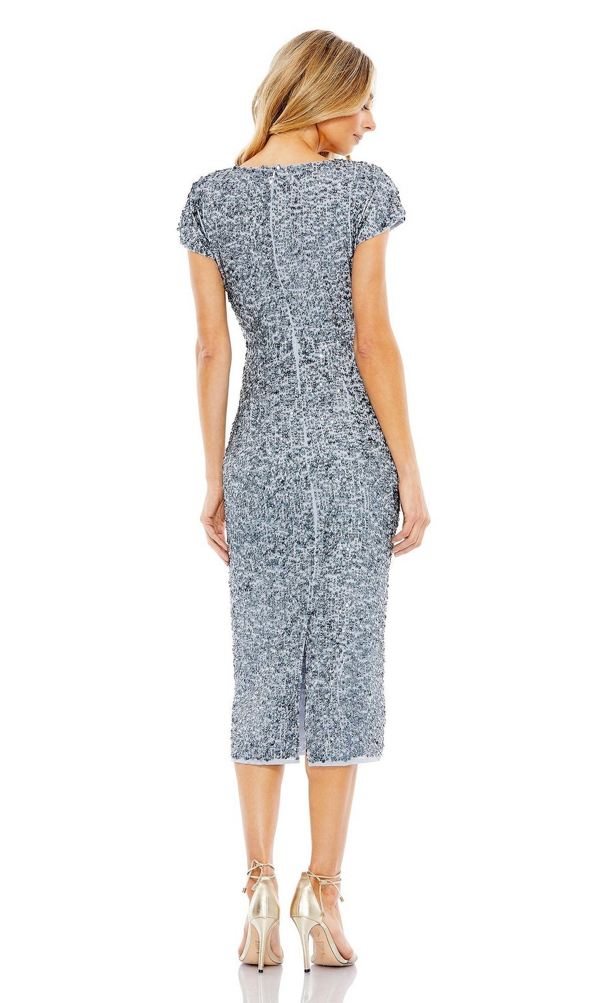 A woman stands facing away in the Mac Duggal 10766 Midi Sequin Wedding Guest Dress, a textured gray cocktail style with short sleeves, paired with beige high-heeled sandals against a plain white background.