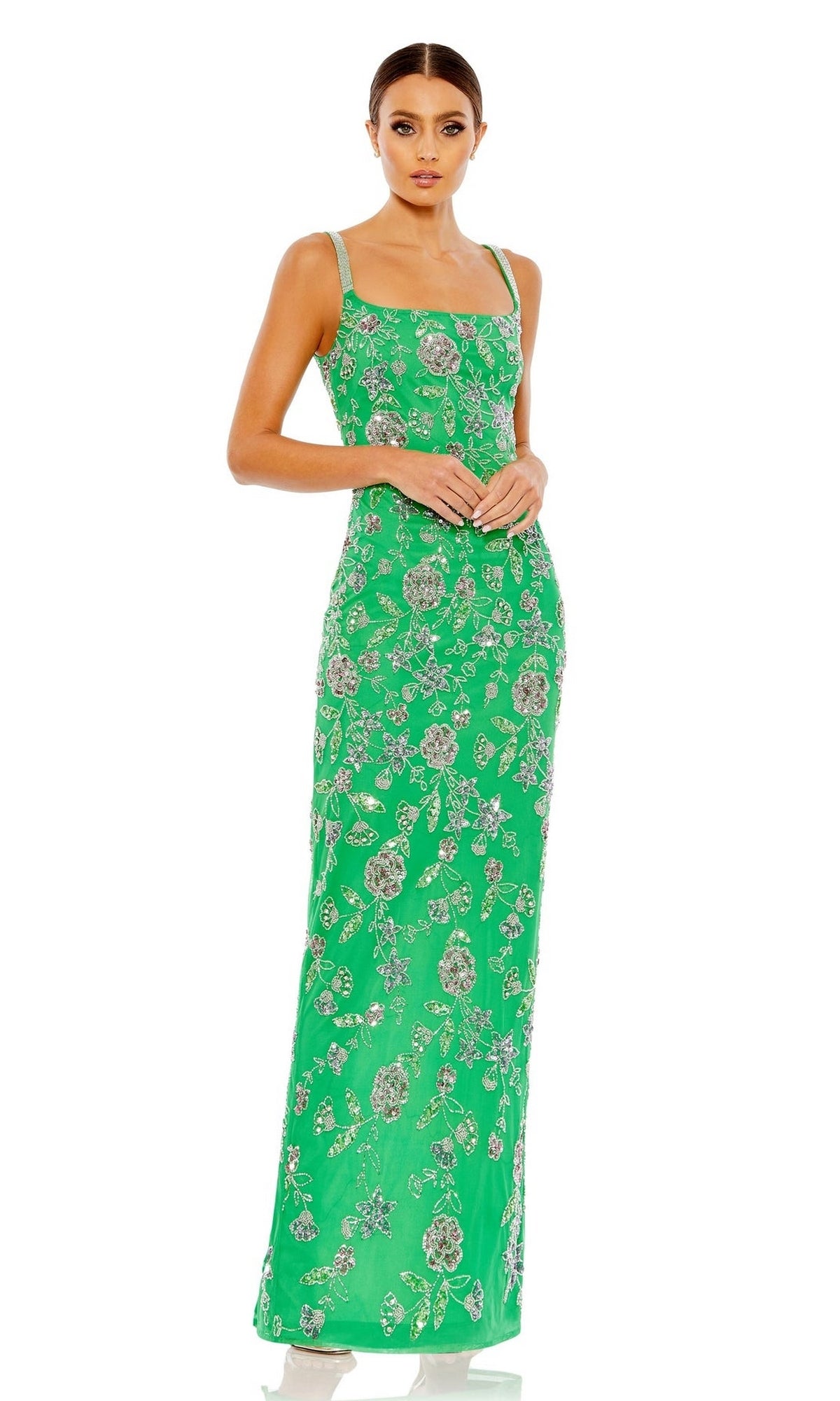 A woman wearing the Long Formal Dress 10808 by Mac Duggal—a fitted green gown with a floral pattern—stands against a white background.