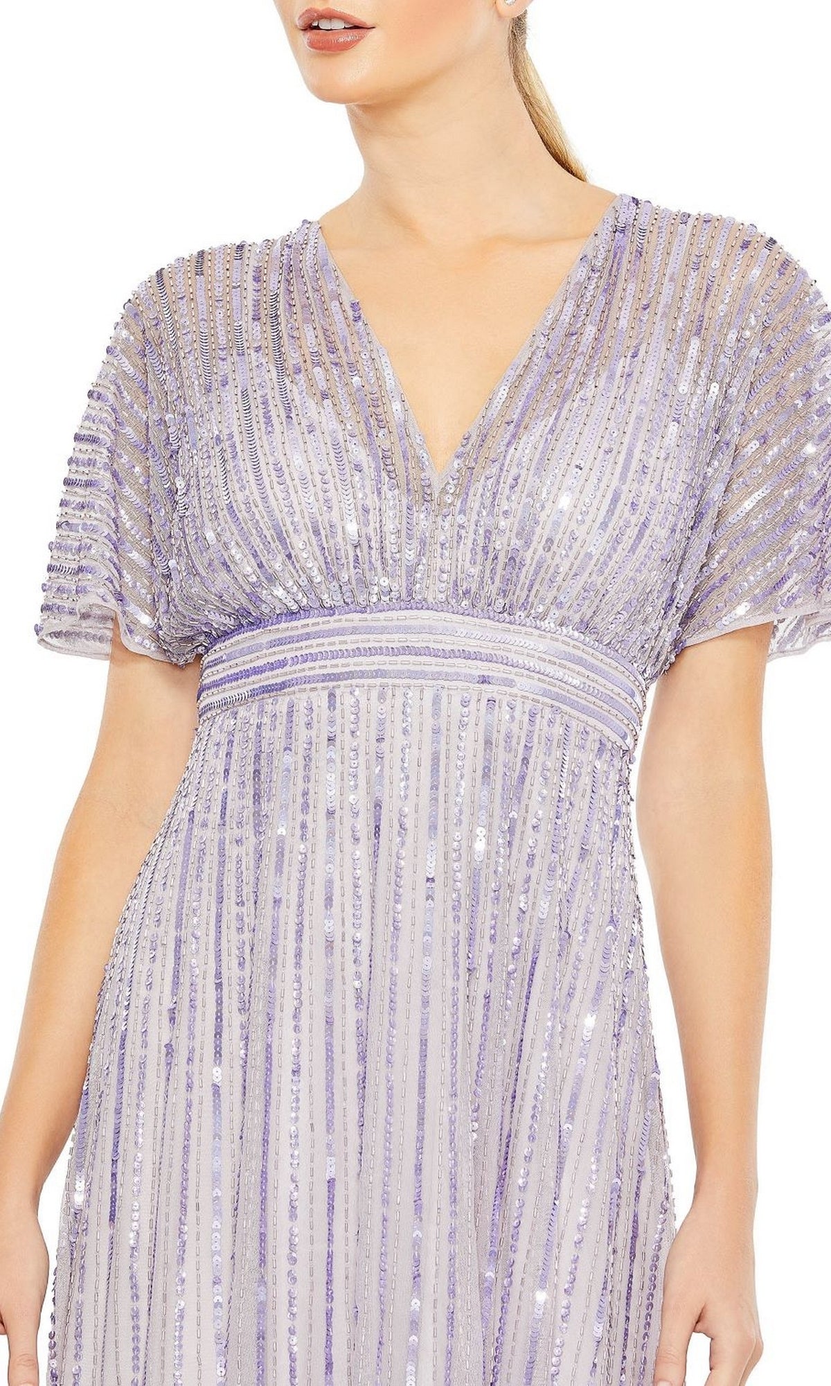 A woman wears the Mac Duggal 10868 Purple Long Sequin Formal Dress featuring a V-neck, short sleeves, and vertical striped detailing.