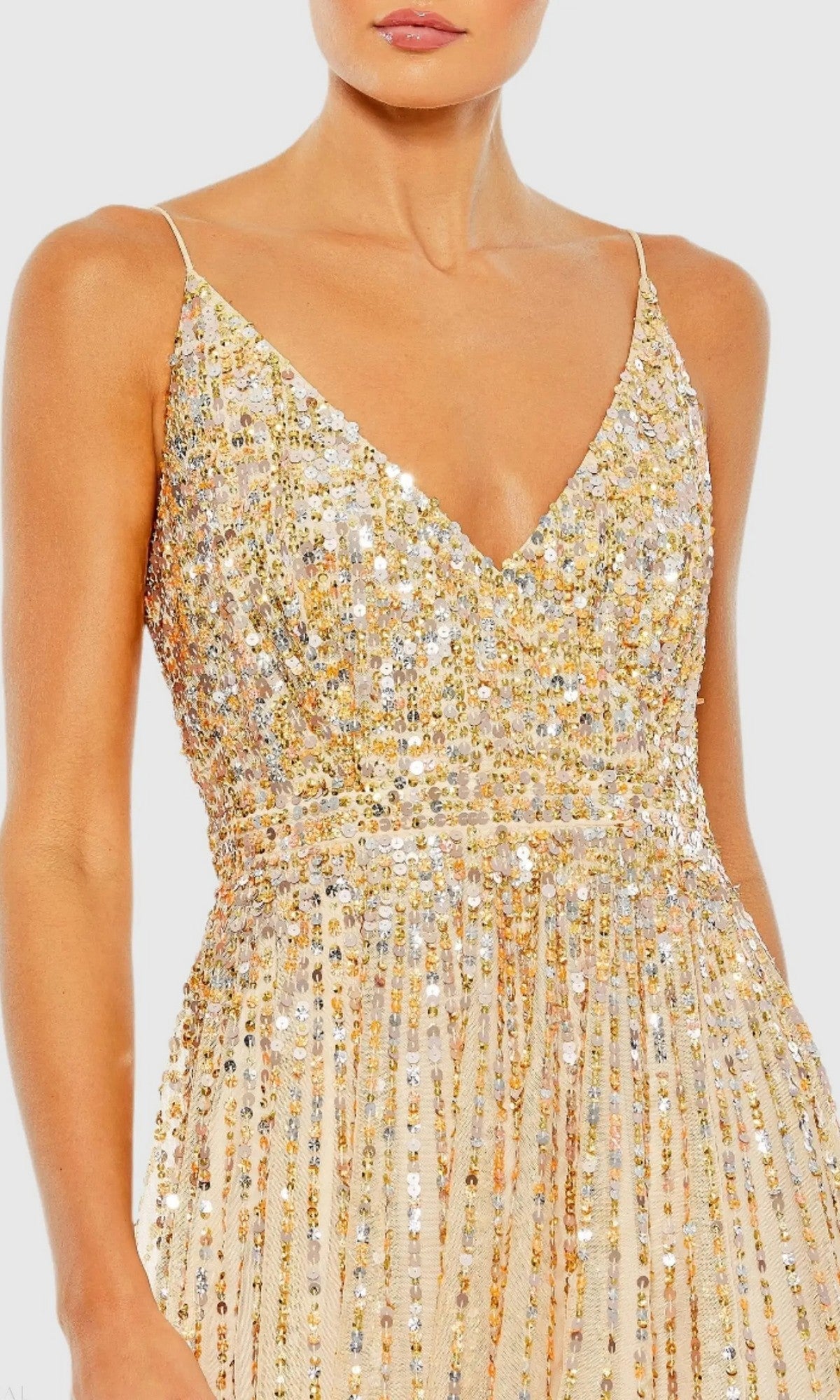 Woman in a Mac Duggal 10928 long formal dress featuring a sleeveless V-neck, fitted bodice, and pleated skirt, embellished with gold and silver sequins on beige fabric.