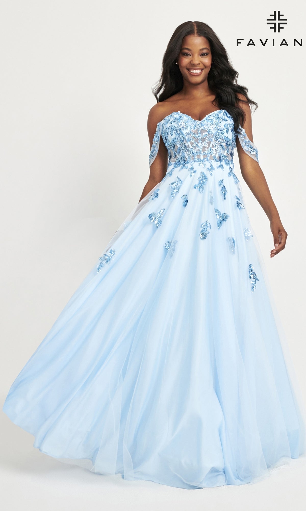 A woman wears the Faviana Off-Shoulder Long A-Line Prom Dress 11059, a light blue gown with floral embroidery and a flowing skirt, standing against a plain background.