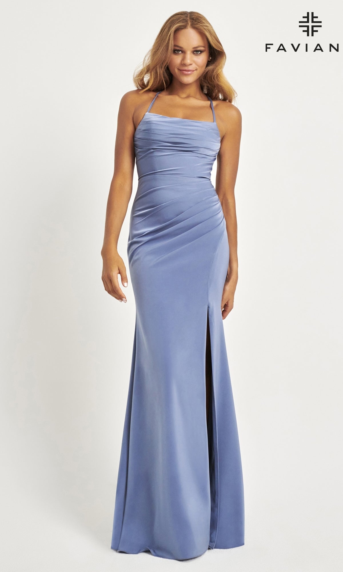 A woman models the Faviana Lace-Up-Back Long Prom Dress 11064, a fitted light blue satin gown with thin straps, side ruching, and a thigh-high slit.