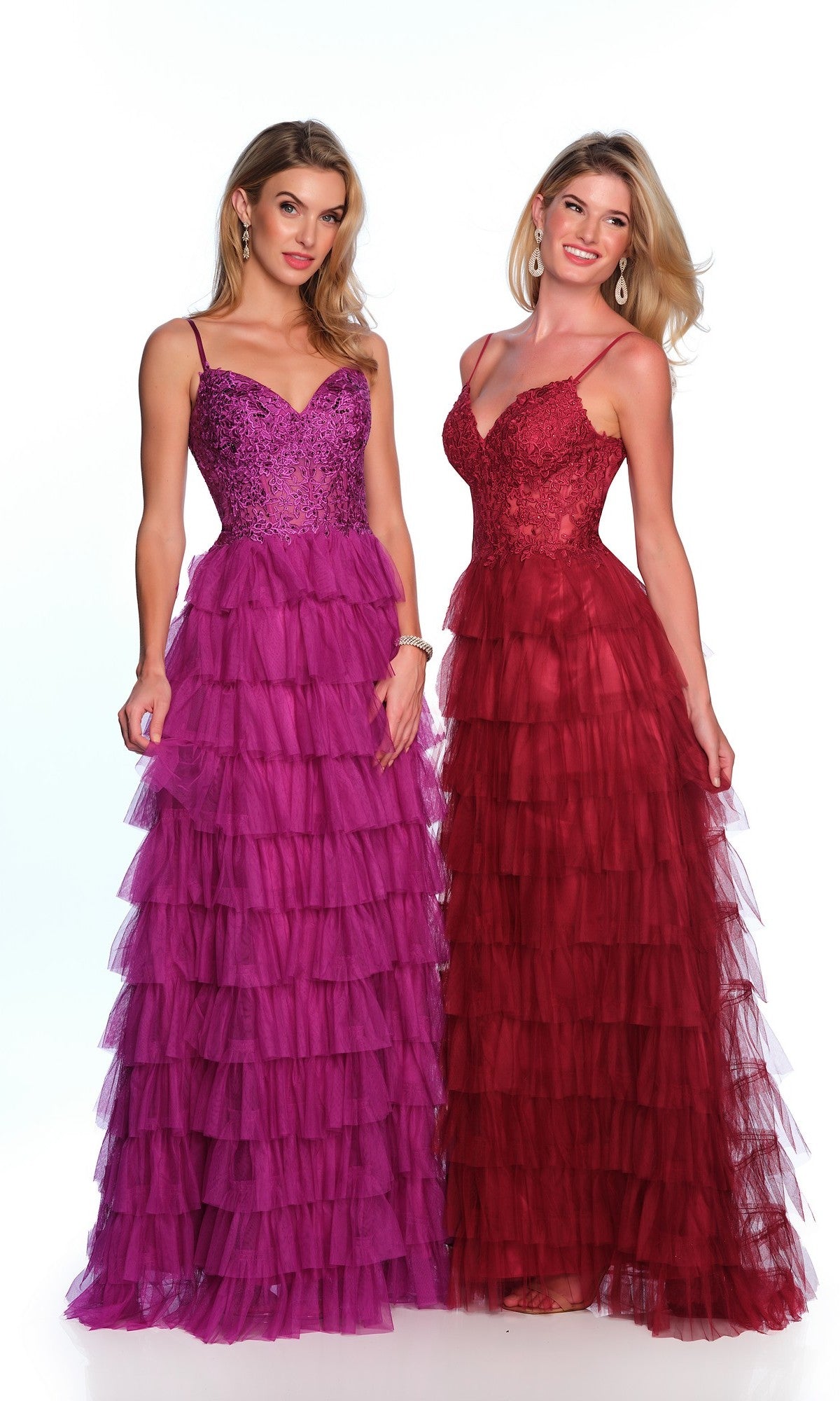 Two women stand side by side in Dave and Johnny Long Tiered Prom Dress 11148—one in a purple sequin-accented design and the other in a red lace v-neck style. Both wear their hair loose and complete the look with elegant earrings.