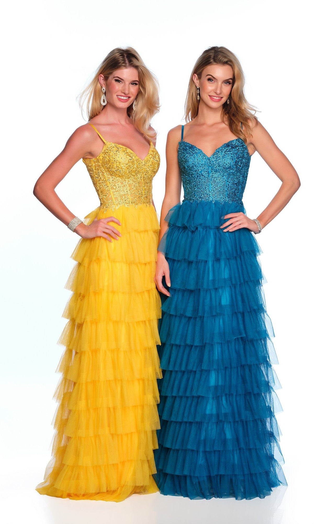 Two women smile brightly at the camera in Dave and Johnny Long Tiered Prom Dress 11148, featuring floor-length ruffled tulle skirts and sequin bodices—one gold on yellow, the other blue on blue—for a stunning formal designer look.
