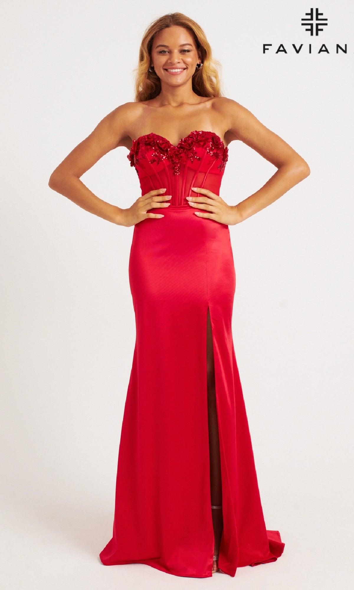 A woman smiles in the Faviana 11248 long prom dress—a strapless, floor-length red gown with a floral embellished corset bodice and thigh-high slit. The Faviana logo is shown in the top right corner.