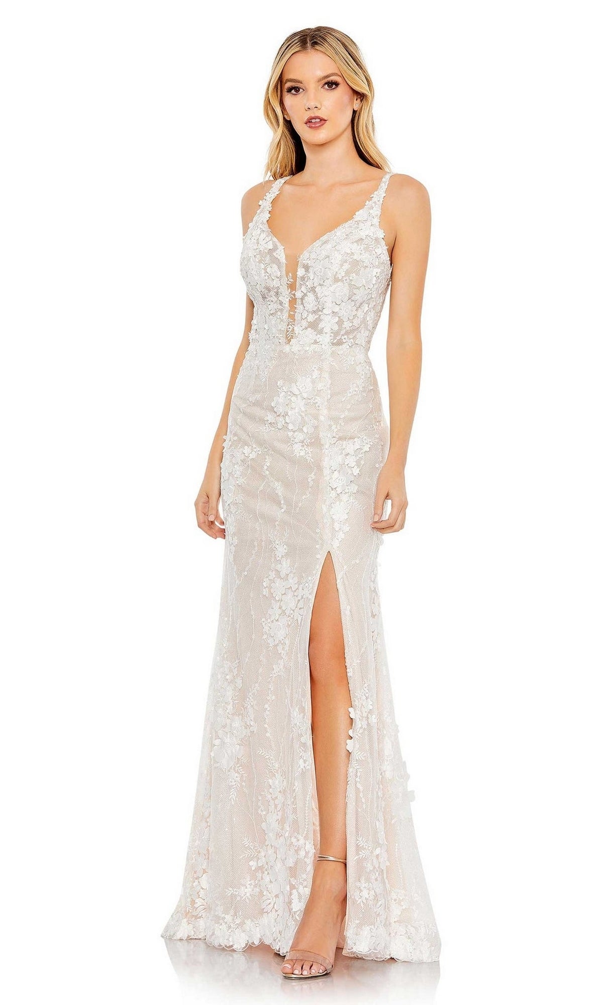 A woman models the Long Formal Dress 11331 by Mac Duggal, featuring a sleeveless, floor-length silhouette with lace embroidery, a plunging V-neckline, floral accents, and a high slit against a plain white background.