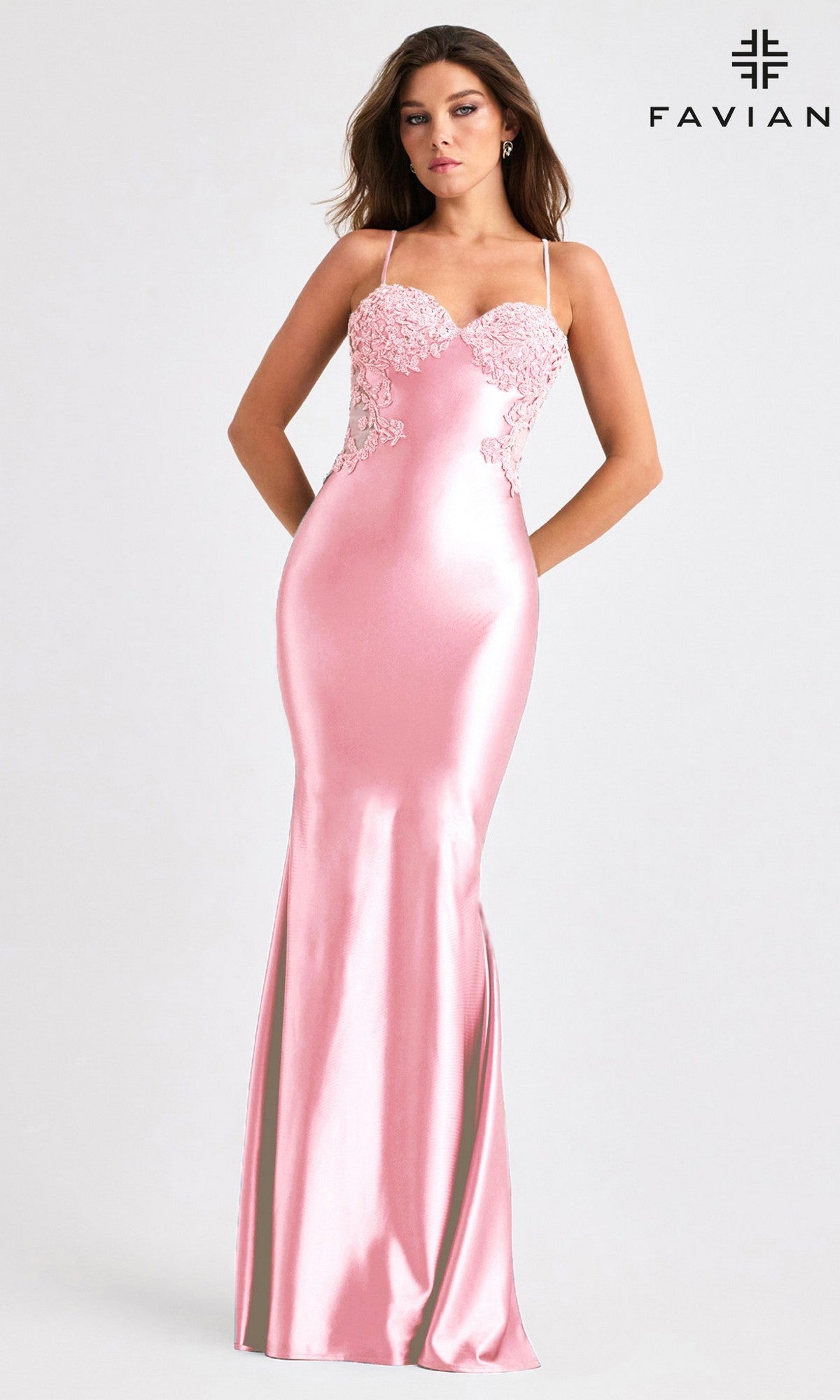 A woman models the Faviana 11403, a fitted, floor-length pink satin prom dress with thin straps and floral lace bodice details, standing against a plain light background.