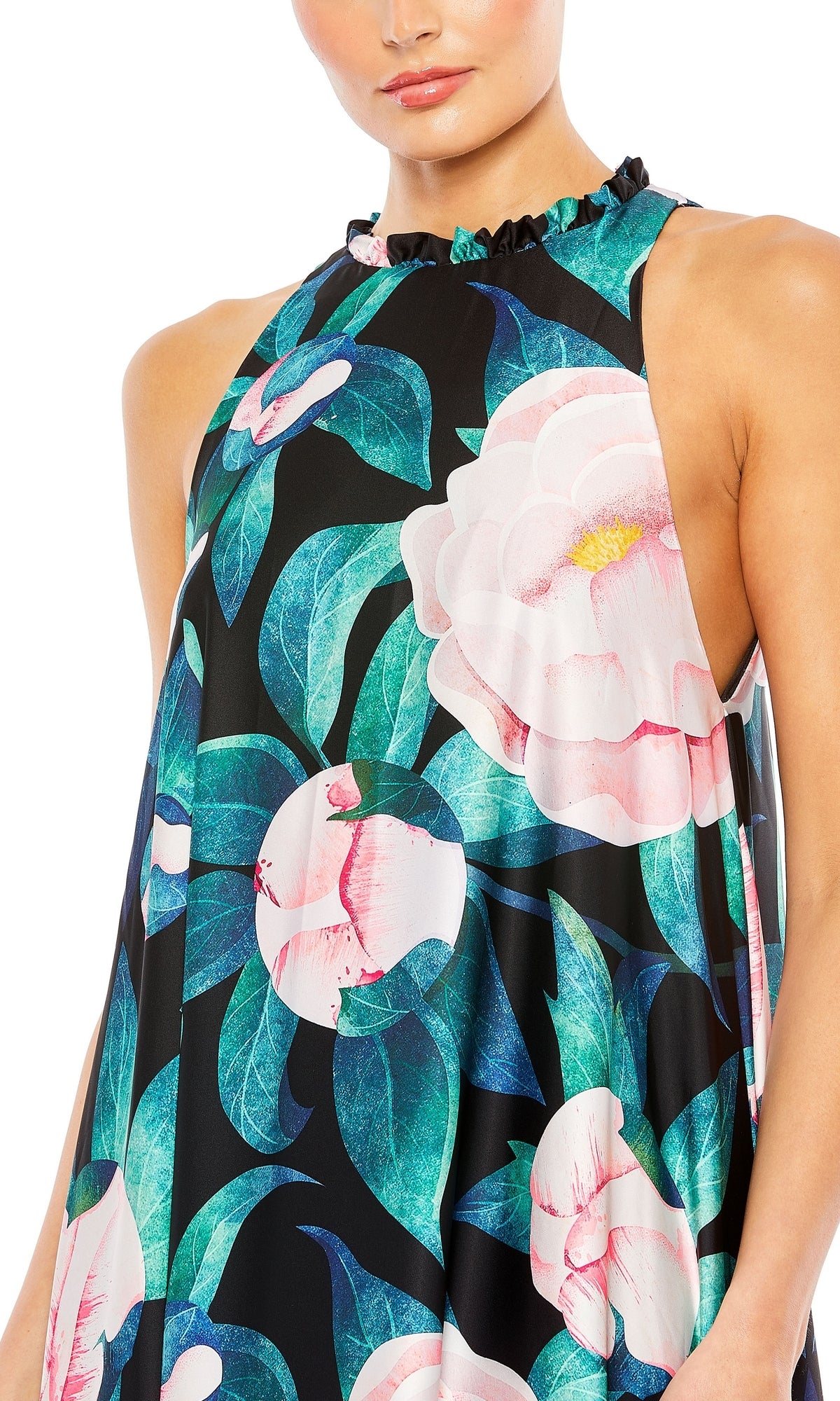 A woman wears the Mac Duggal 11406 Floral-Print Long Formal Dress, a sleeveless, high-neck gown with ruffles and bold pink flowers with green leaves on a black background.