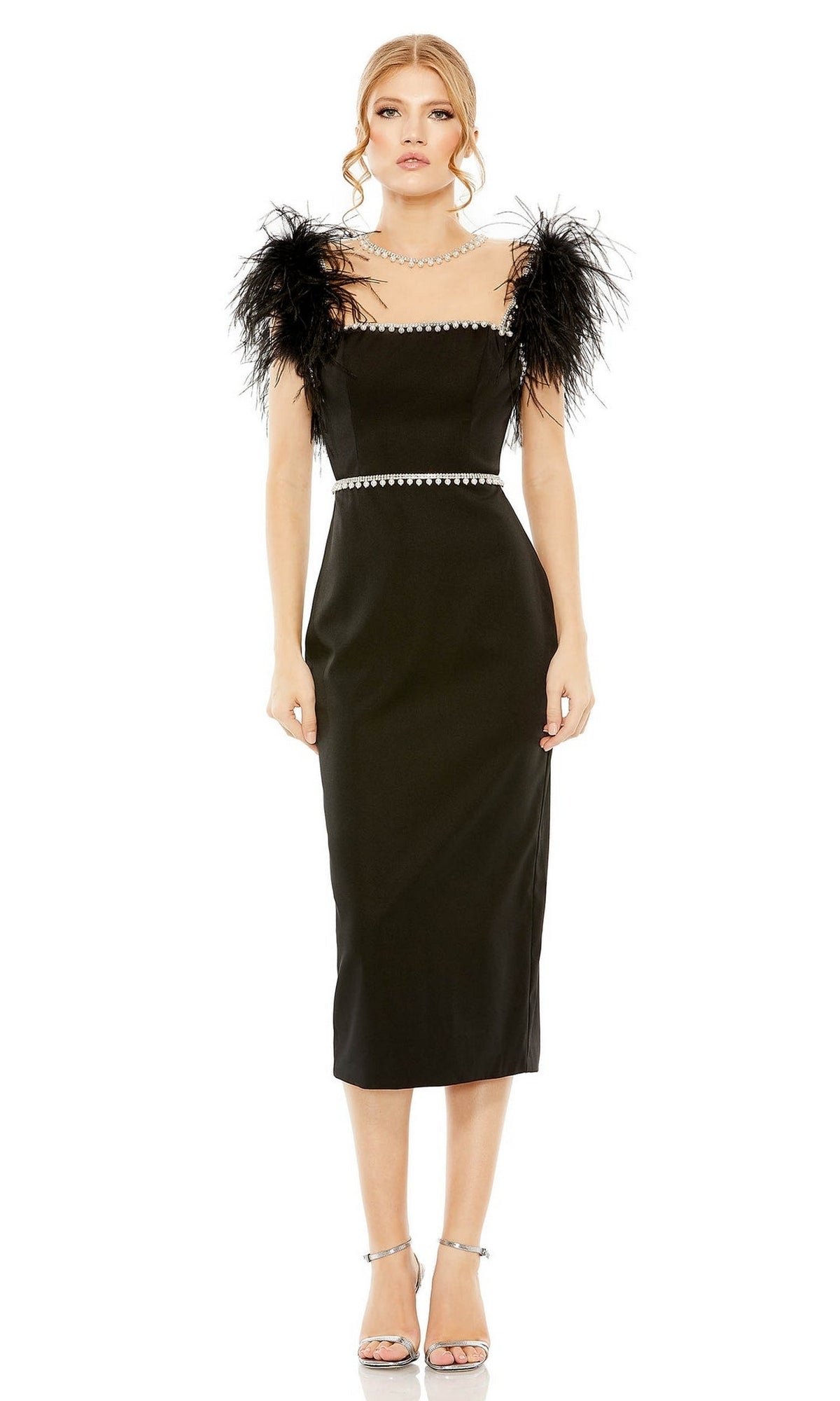 A woman models the Mac Duggal 11438 Sheer High-Neck Wedding-Guest Dress—black, midi length, with feathered shoulders and silver trim—paired with silver high heels, against a white background.