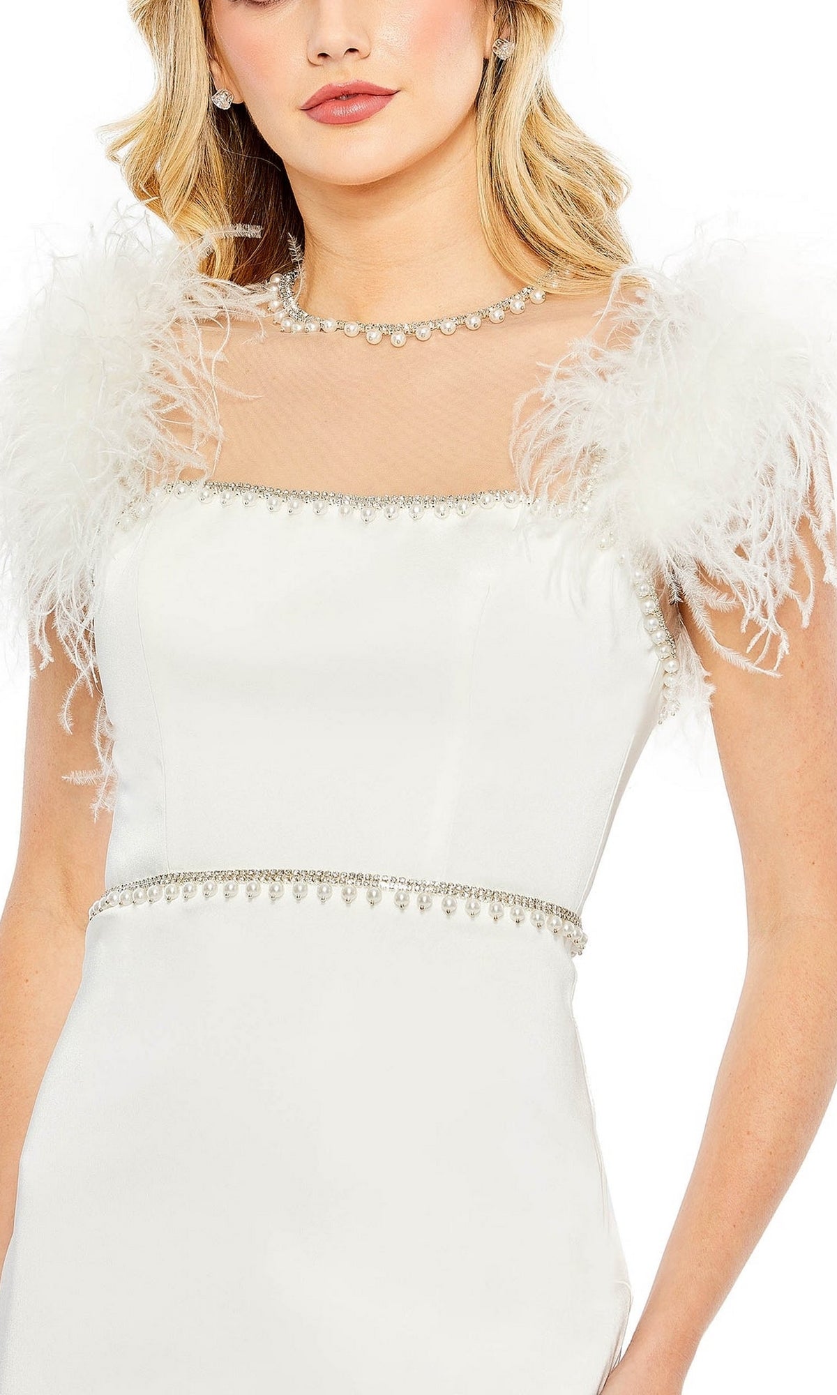 A woman poses against a white background in the Mac Duggal 11438 Sheer High-Neck Wedding-Guest Dress, featuring a white, knee-length design with feathered shoulders, jeweled neckline, and waistband.