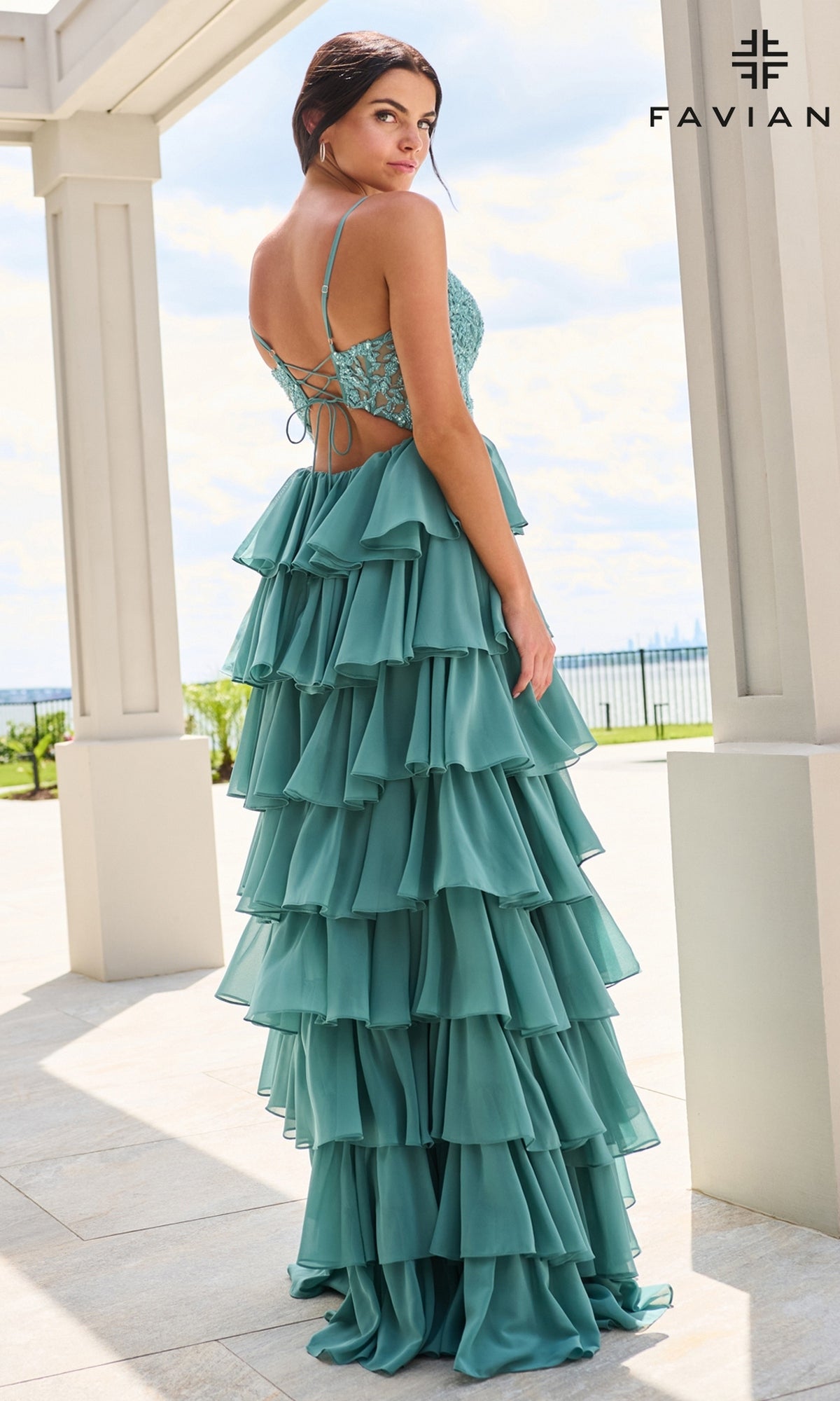 Faviana 11603 is a teal, floor-length prom dress featuring a corset bodice, lace-up back, and a tiered, chiffon ruffle skirt.