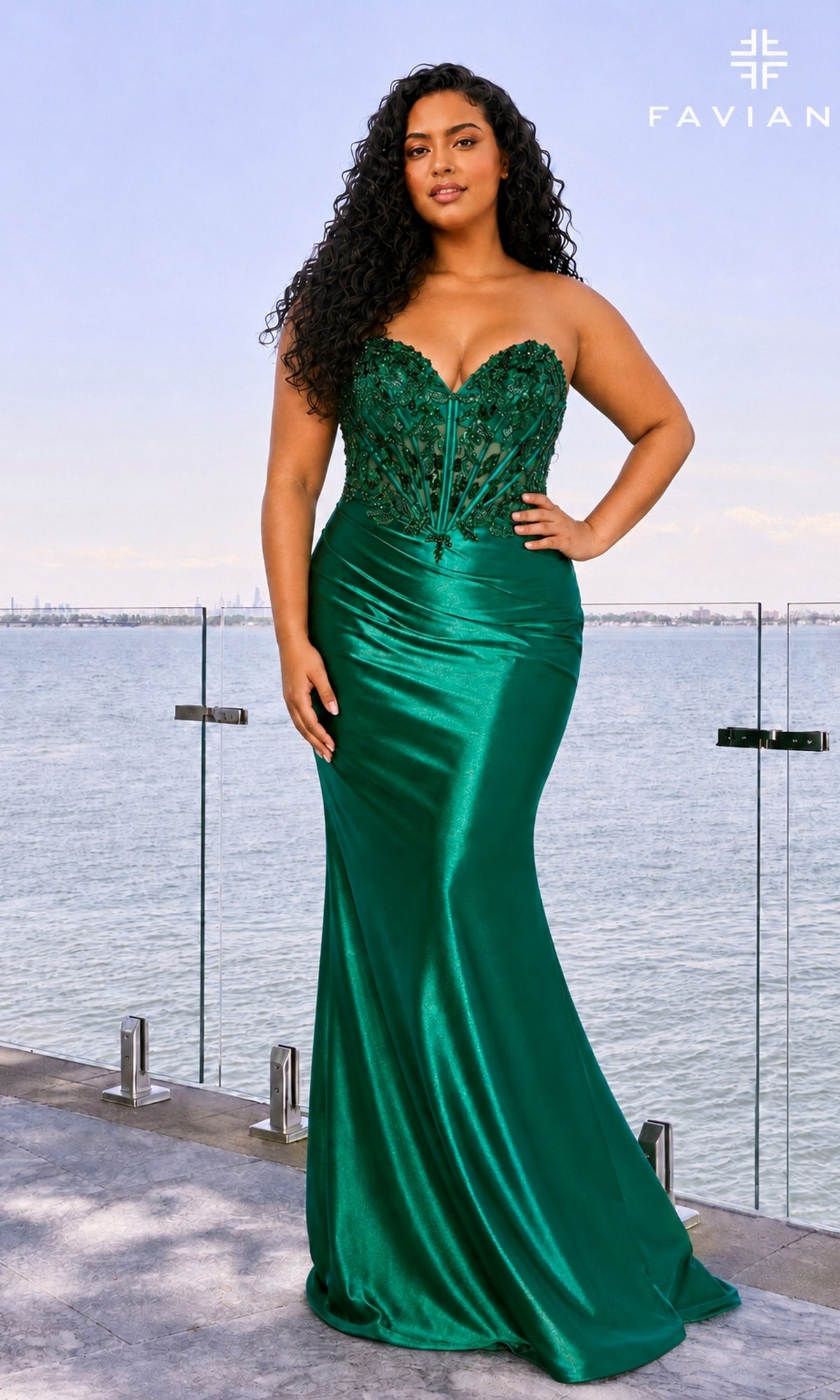 A woman wears a Long Plus-Size Prom Dress: Faviana 11607E in dark emerald, featuring a strapless corset gown with a fitted, embellished bodice and a floor-length satin skirt.