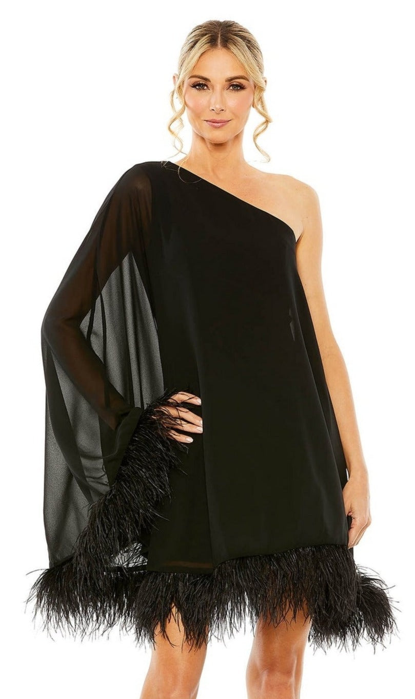 A woman wears the Mac Duggal 11623 short wedding guest dress, featuring a one-shoulder design, sheer sleeve, and feather-trimmed hem, standing against a white background—an elegant look for special occasions.