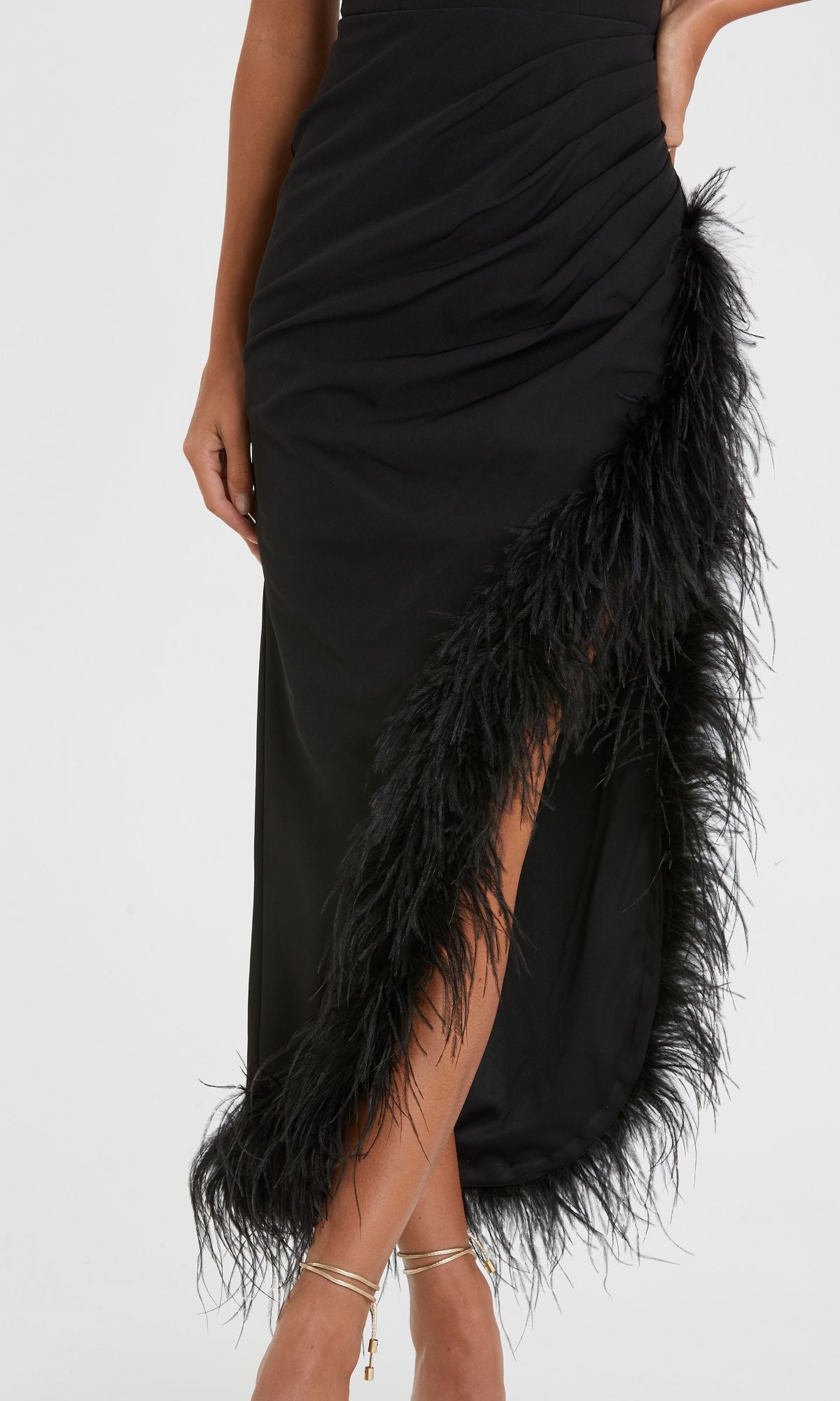 Wearing the Mac Duggal 11626 Feather Midi Wedding-Guest Dress, featuring ruched details, feather trim, and a thigh-high slit, a person stands confidently with one hand on their hip.