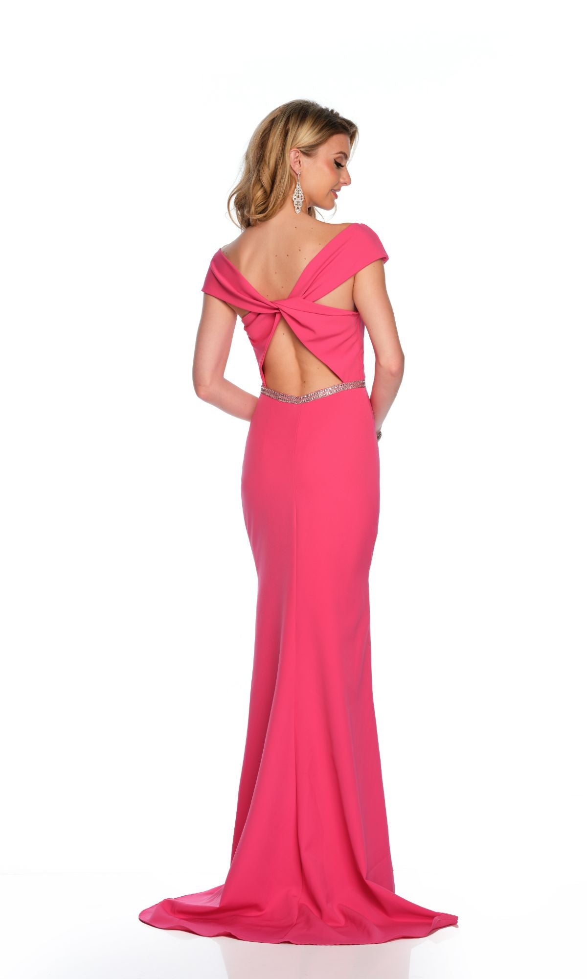 A woman models the Long Formal Dress 11629 by Dave and Johnny—a fitted, floor-length fuchsia gown with a beaded belt and twisted open back—posing against a white background.