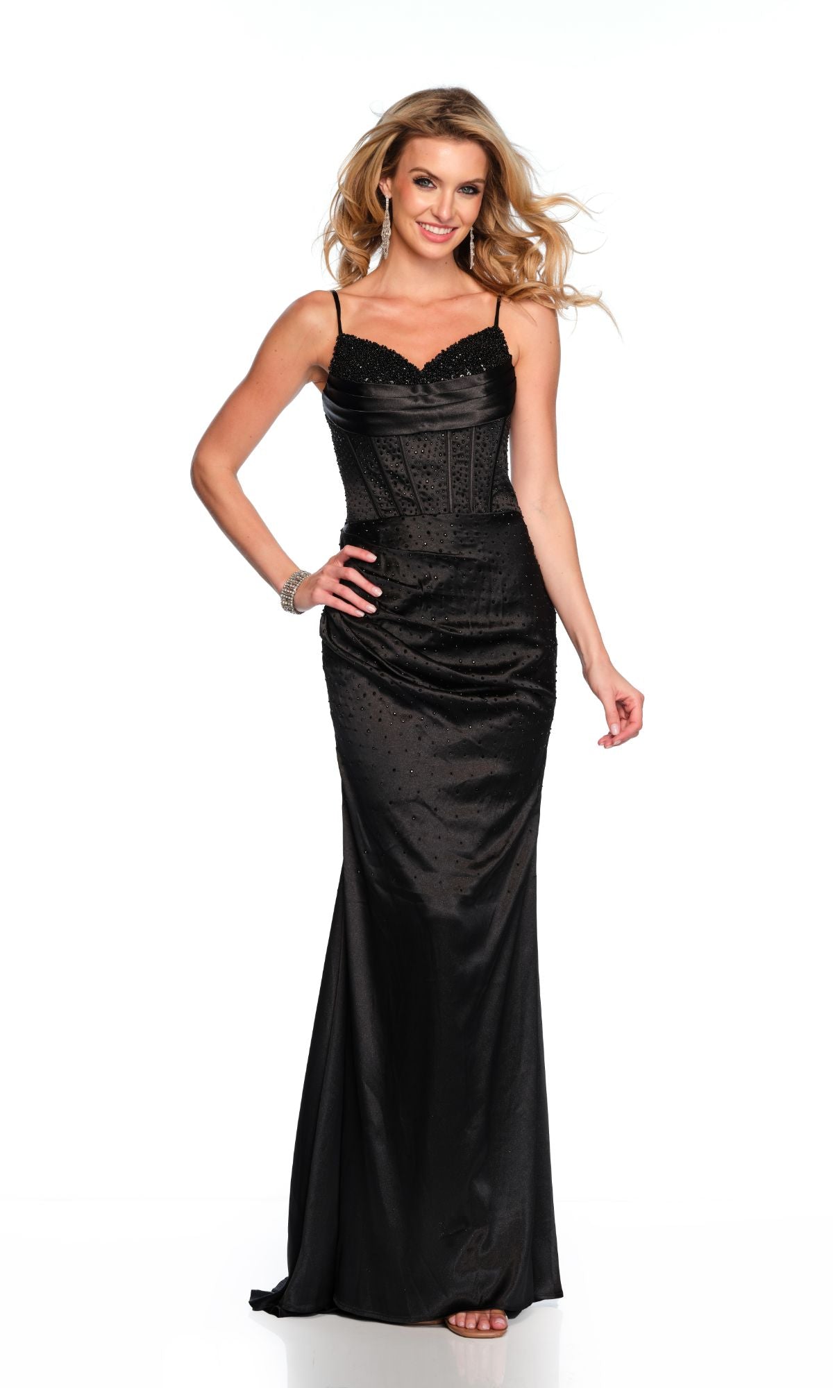 A woman stands and smiles in the Long Formal Dress 11647 by Dave and Johnny—black, fitted, with spaghetti straps and a v-neckline—against a plain white background.