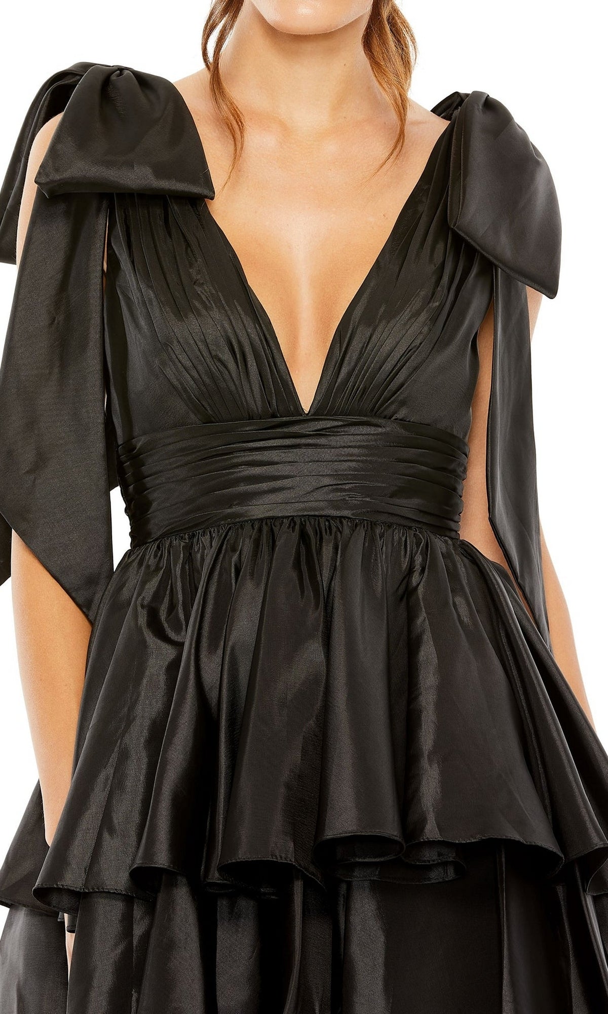A woman wears the Mac Duggal 11657 Bow Short Ruffled Hoco Dress—black, sleeveless, with large shoulder bows and a gathered ruffled peplum waist.
