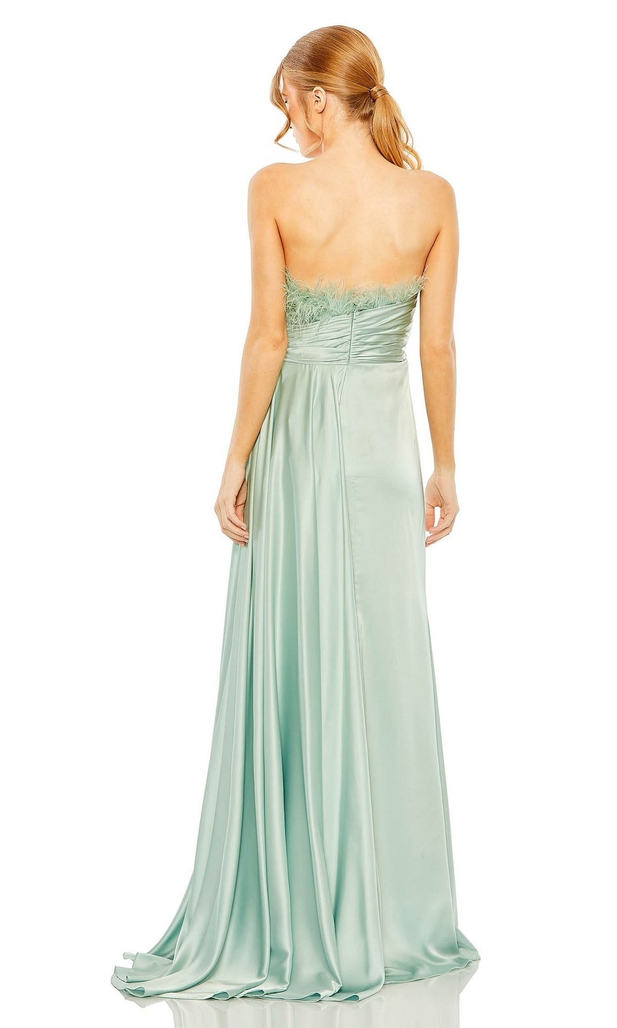 A woman showcases the Long Formal Dress 11690 by Mac Duggal—a seafoam green satin strapless gown with a feathered bodice—elegantly displayed from the back.
