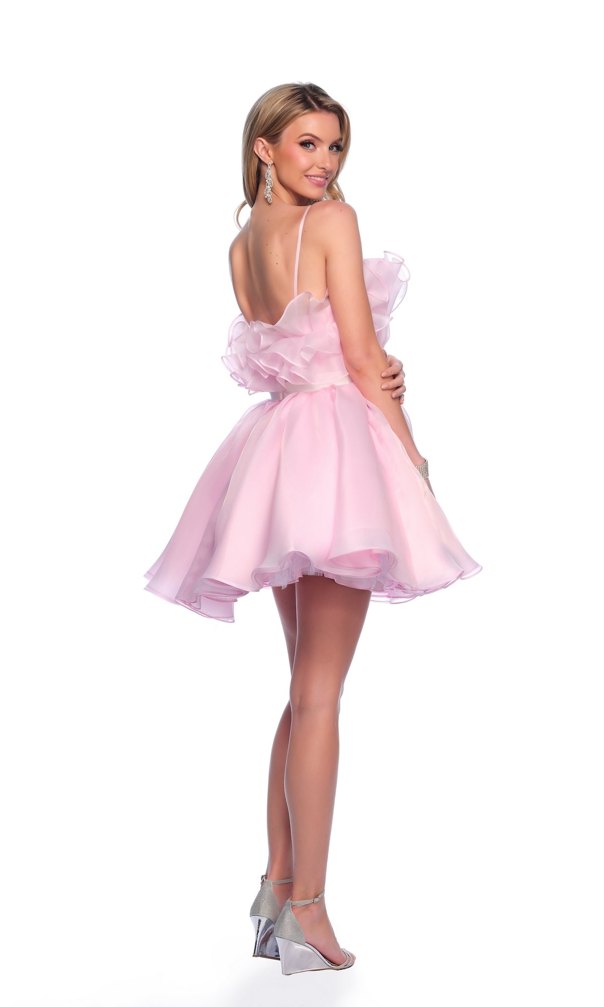 Woman in a light pink, ruffled, sleeveless mini dress with thin straps and silver heels poses against a white background—wearing the Dave and Johnny Short Pink Ruffle Hoco Dress 11730, perfect for homecoming.