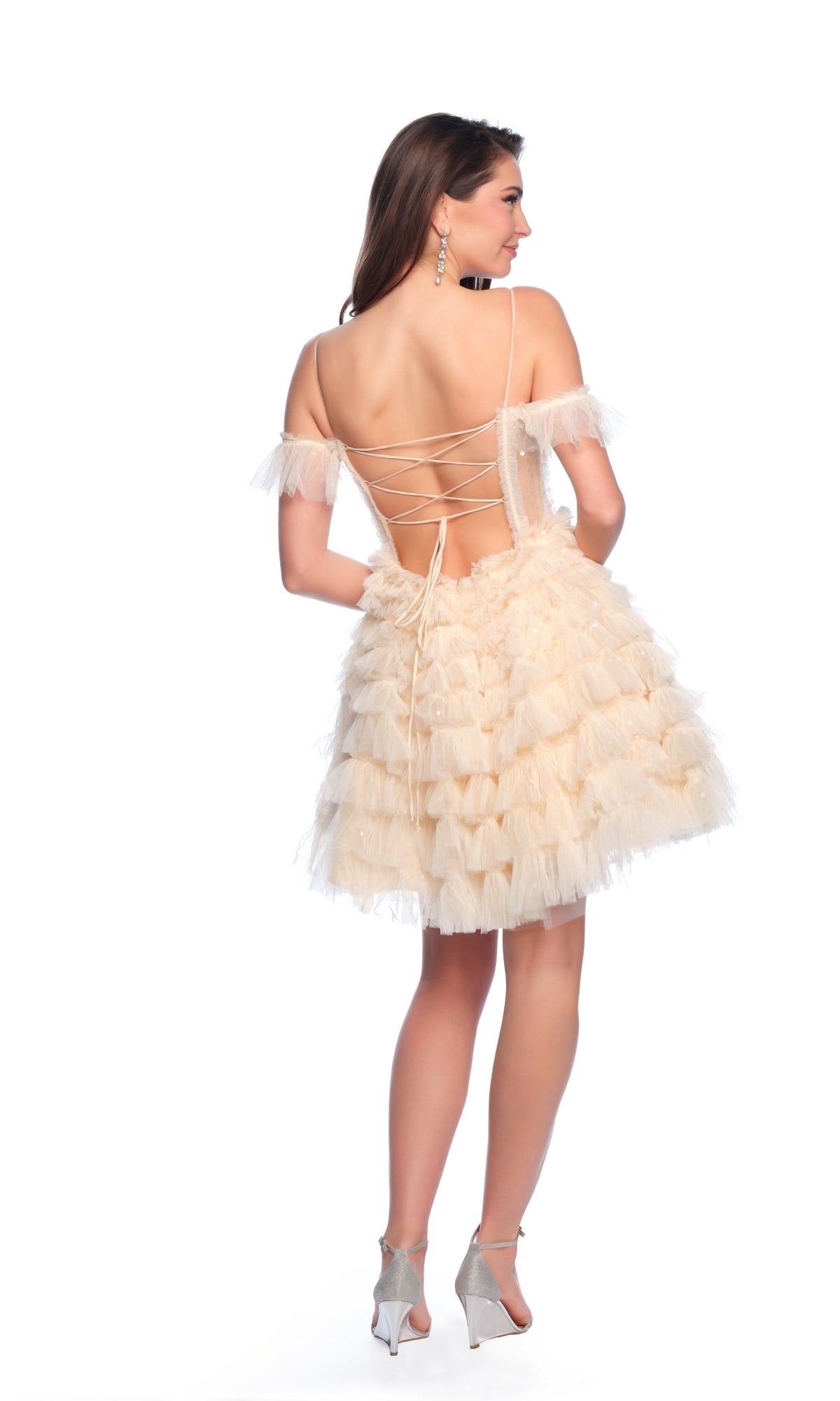 Woman in the Dave and Johnny Short Ruffled Hoco Dress 11754, featuring a champagne A-line skirt and lace-up back, stands in heels against a white background, shown from behind.