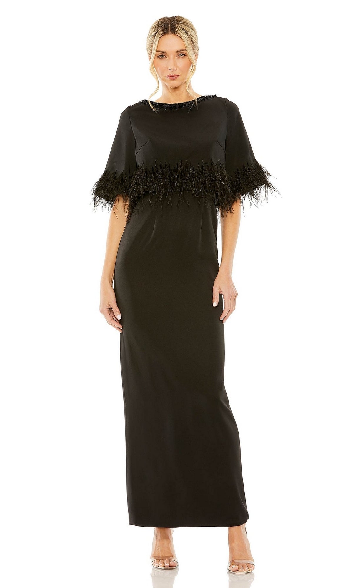A woman wears the Mac Duggal 11787 short-sleeve black formal dress with a sleek silhouette and pairs it with clear high-heeled shoes.