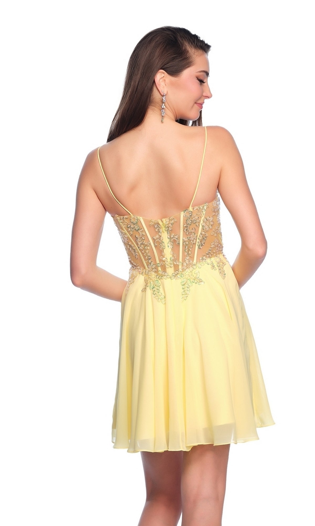 A woman faces away from the camera wearing the Dave & Johnny Short Chiffon Hoco Dress 11789 in yellow, featuring a sheer back and floral embroidery.