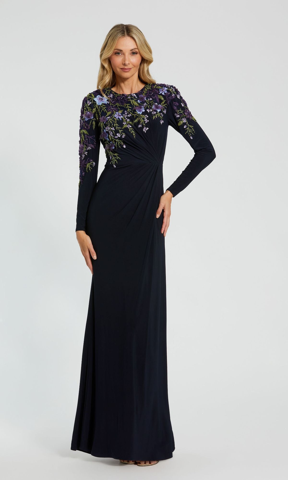A woman wearing the Long Sleeve Blue Formal Dress by Mac Duggal 11806 stands against a plain background.