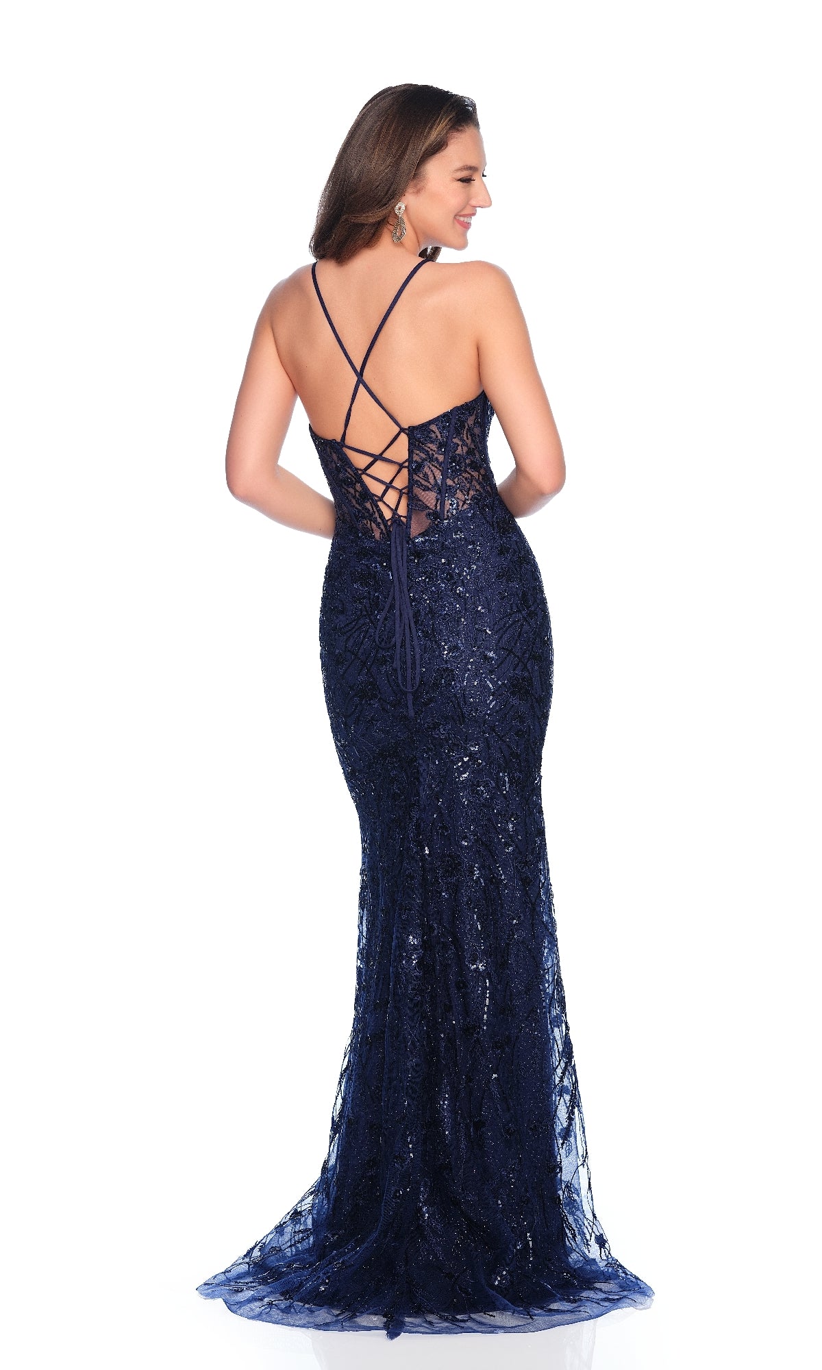 A woman stands on a white background wearing the Dave & Johnny 11838 long prom dress—navy blue, floor-length, with sequin lace, fitted silhouette, corset bodice, and a crisscross lace-up open back.