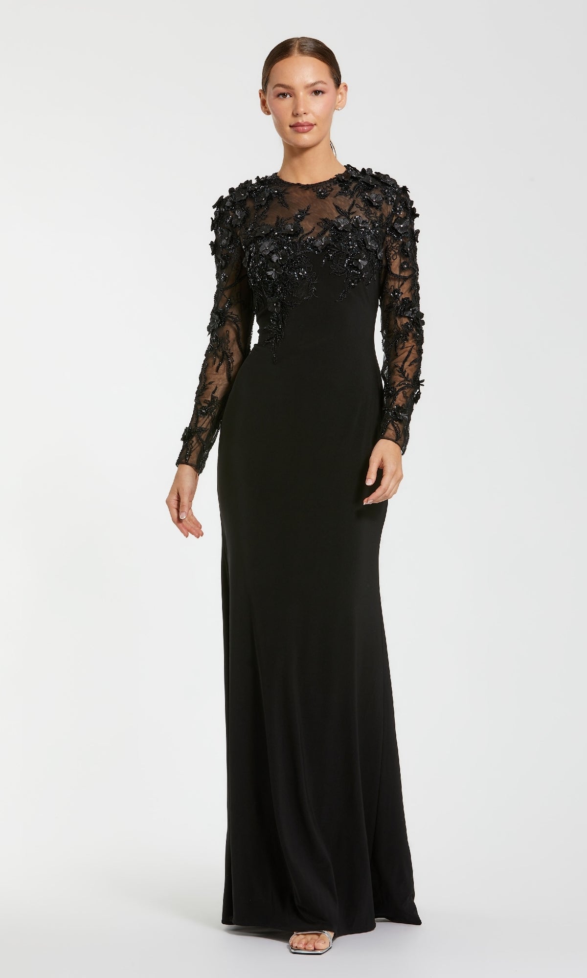 Black evening gown with sheer long sleeves on a white background