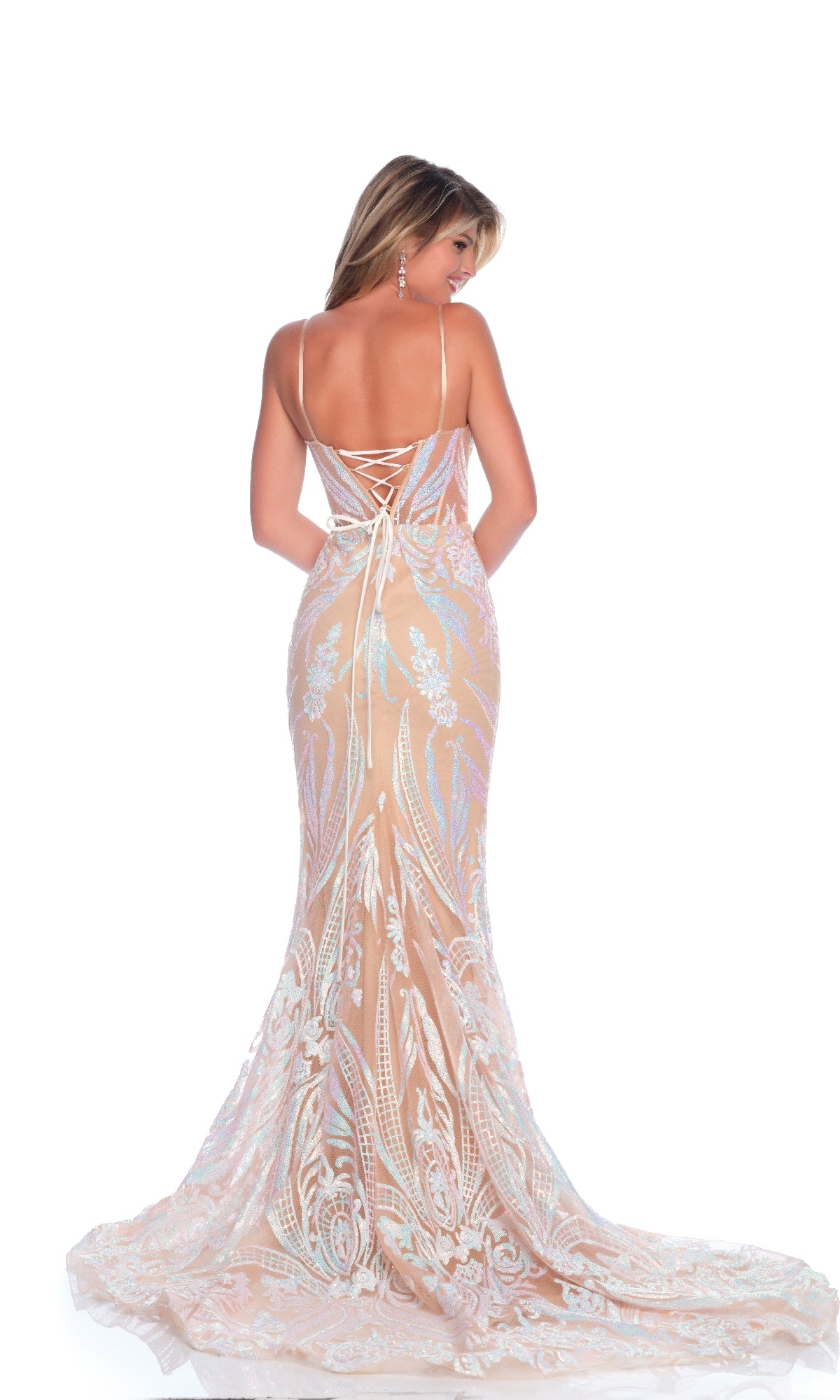 A woman wearing the Dave and Johnny 12001 long prom dress stands with her back to the camera, showcasing its fitted, floor-length nude design with a lace-up open back and intricate white lace patterns against a white background.