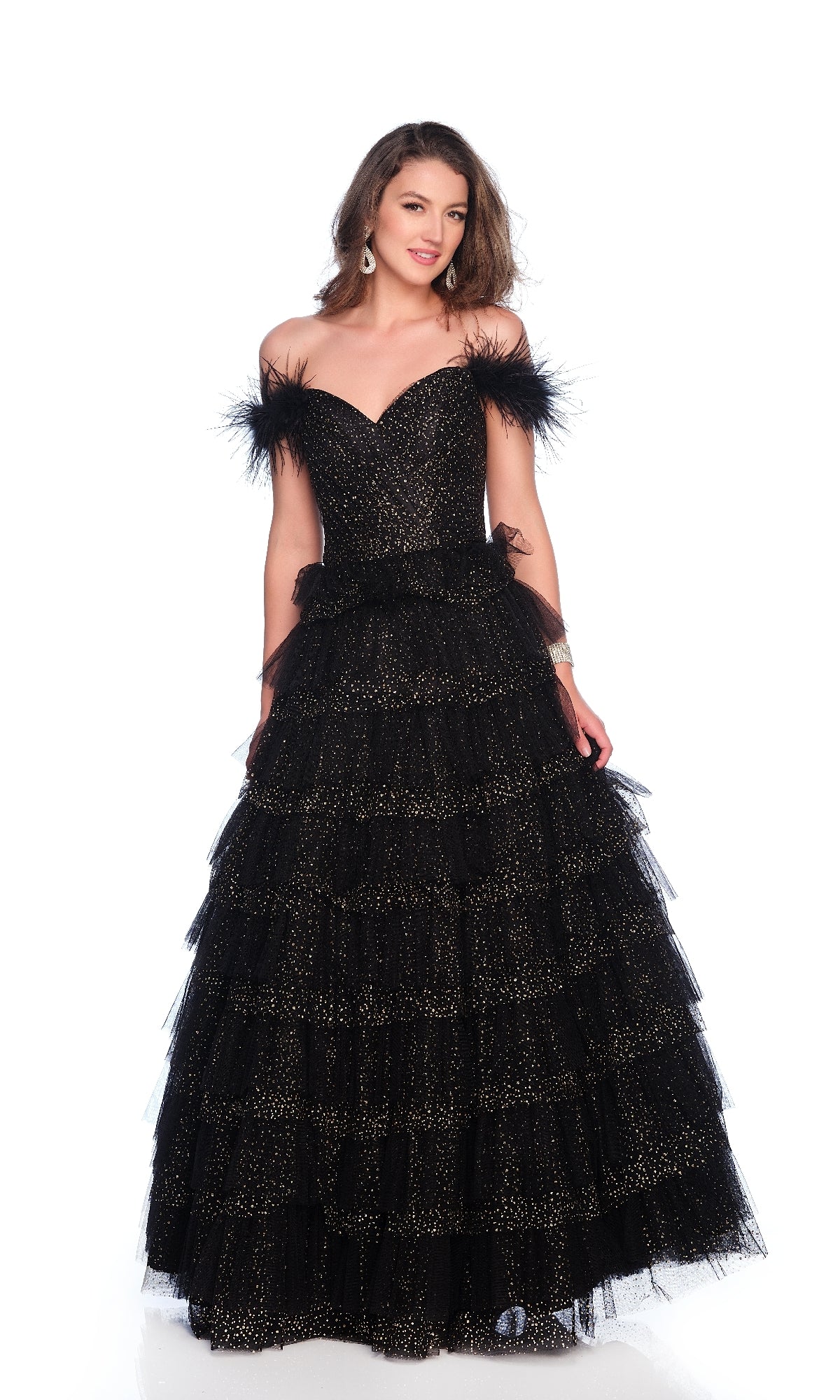 A woman models the Sparkly Black Prom Ball Gown: Dave & Johnny 12129, featuring feathered straps, a tiered floor-length skirt, and a glittery black pattern against a white background.