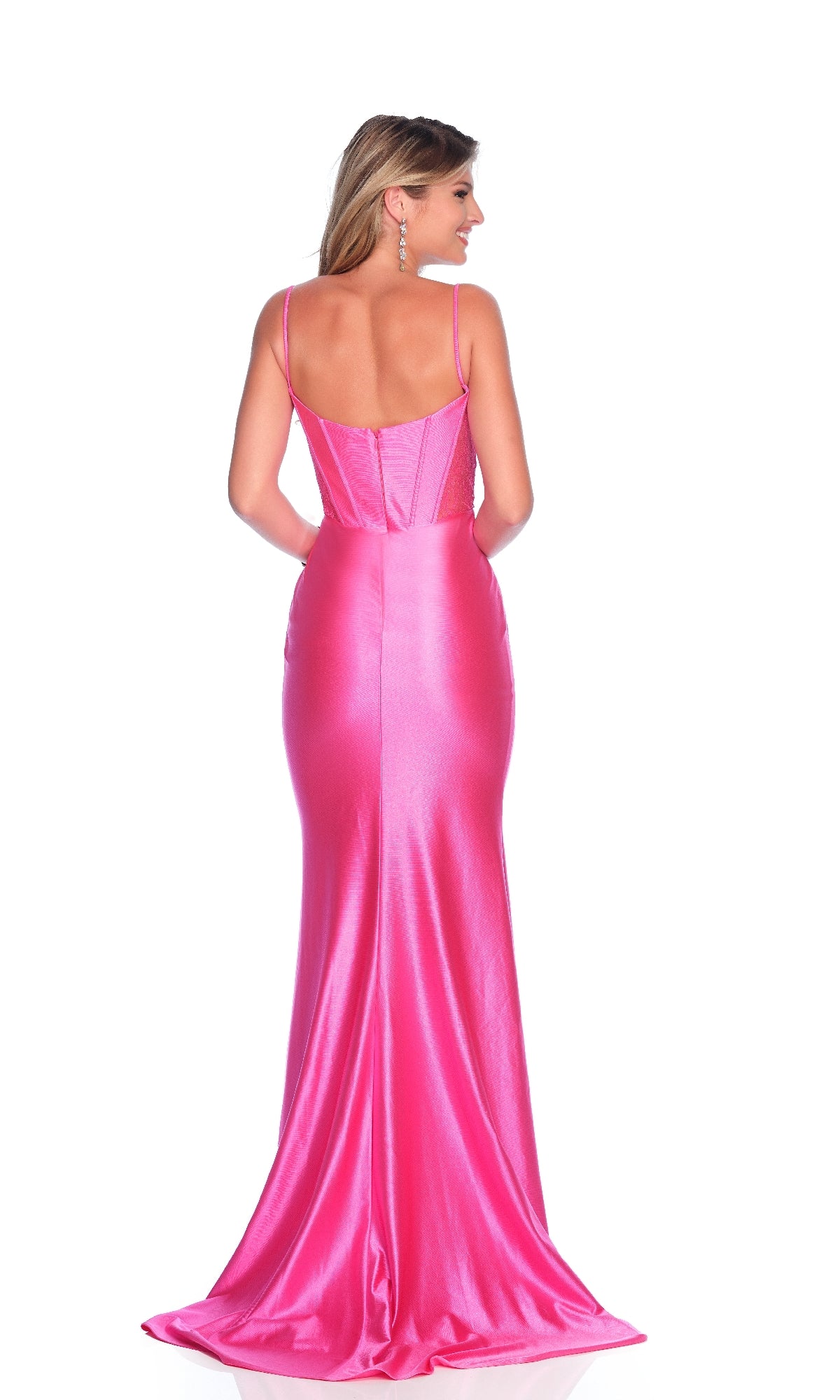 A woman faces away, wearing the fitted hot pink Dave and Johnny 12159 long prom dress with spaghetti straps and a train, set against a white background.