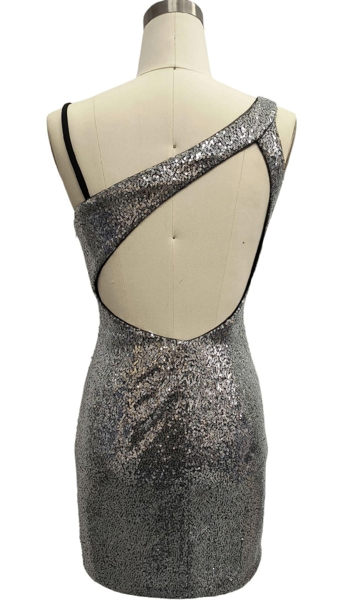 Short Silver Homecoming Dress: 12360 with an asymmetrical neckline, cutout back detail, and fitted silhouette is displayed on a dress form.