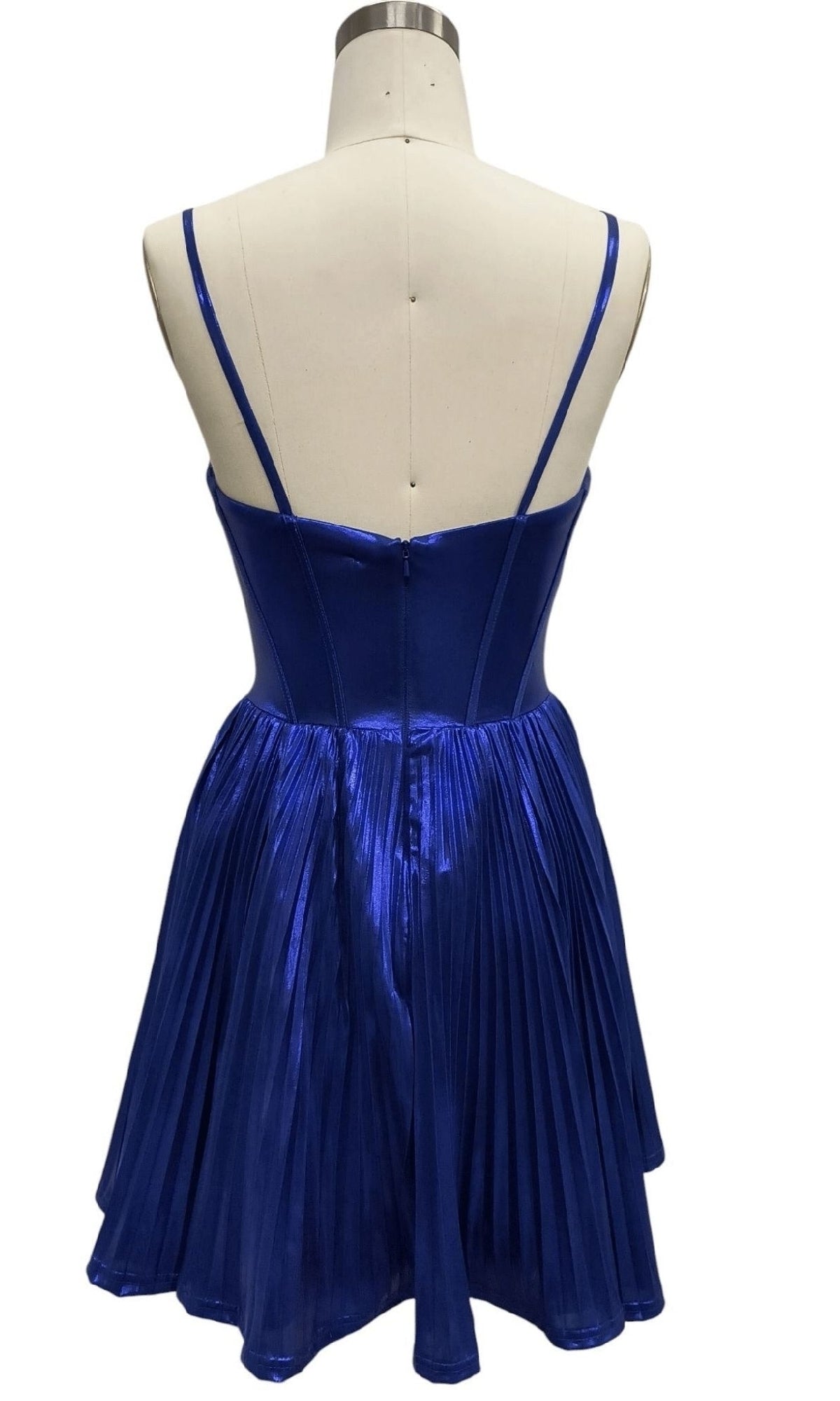 A mannequin showcases the Royal Blue Short Hoco Dress: 12388, featuring a shiny metallic finish, thin straps, fitted bodice, and pleated short A-line skirt—an ideal standout choice for any party.